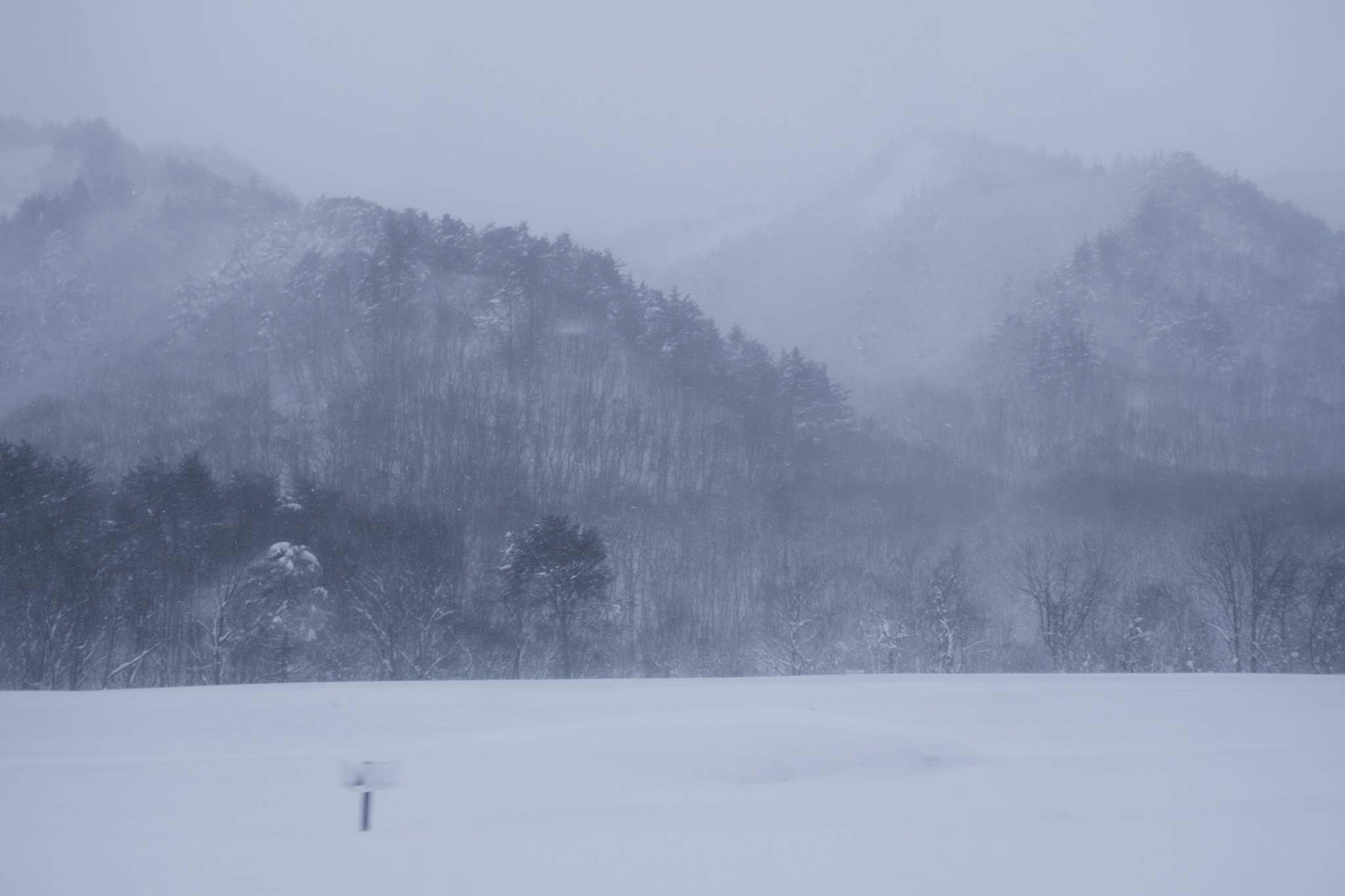 Isolated figure in a snowy landscape with mountains in the background