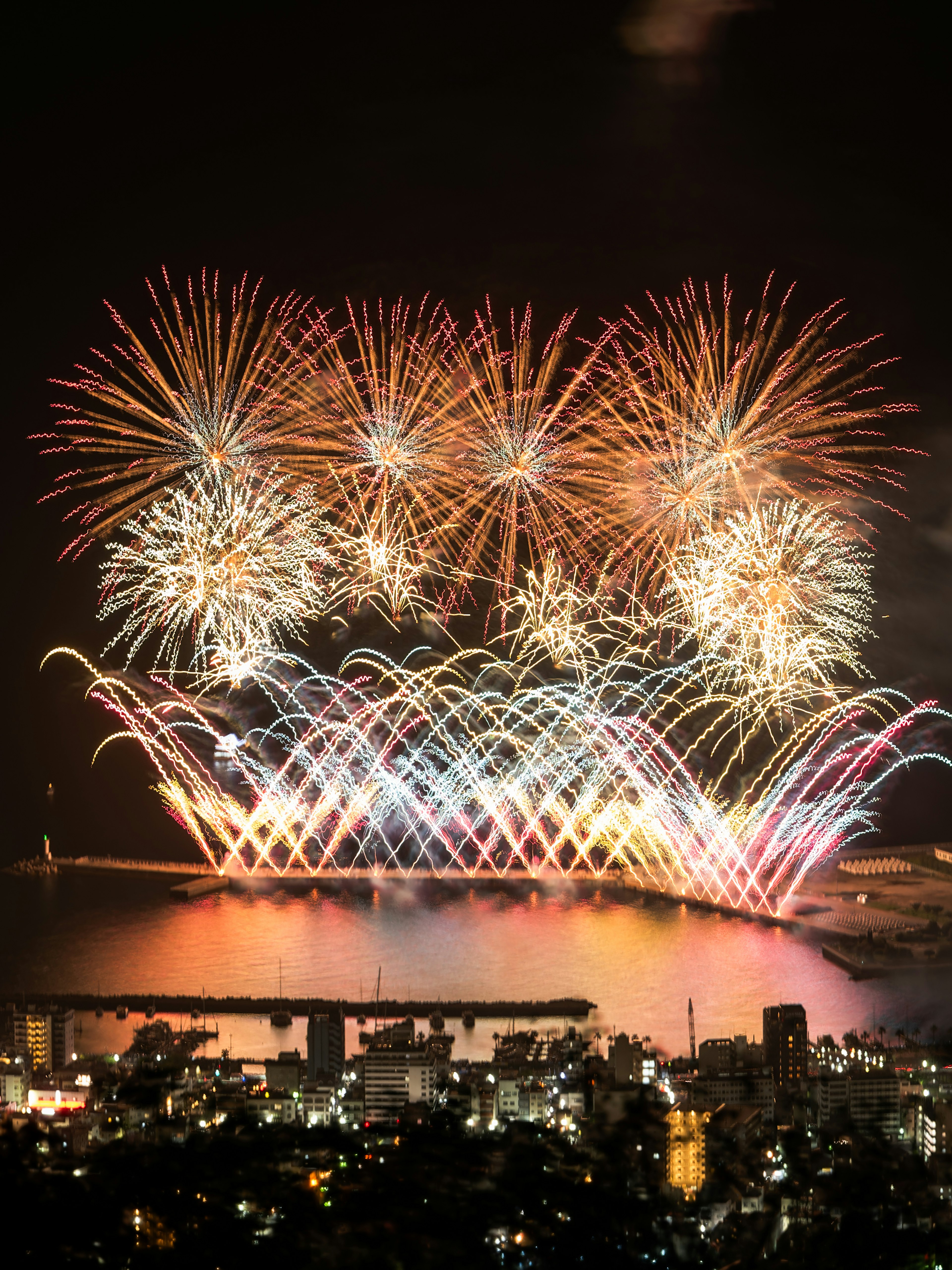 Vibrant fireworks lighting up the night sky over the sea