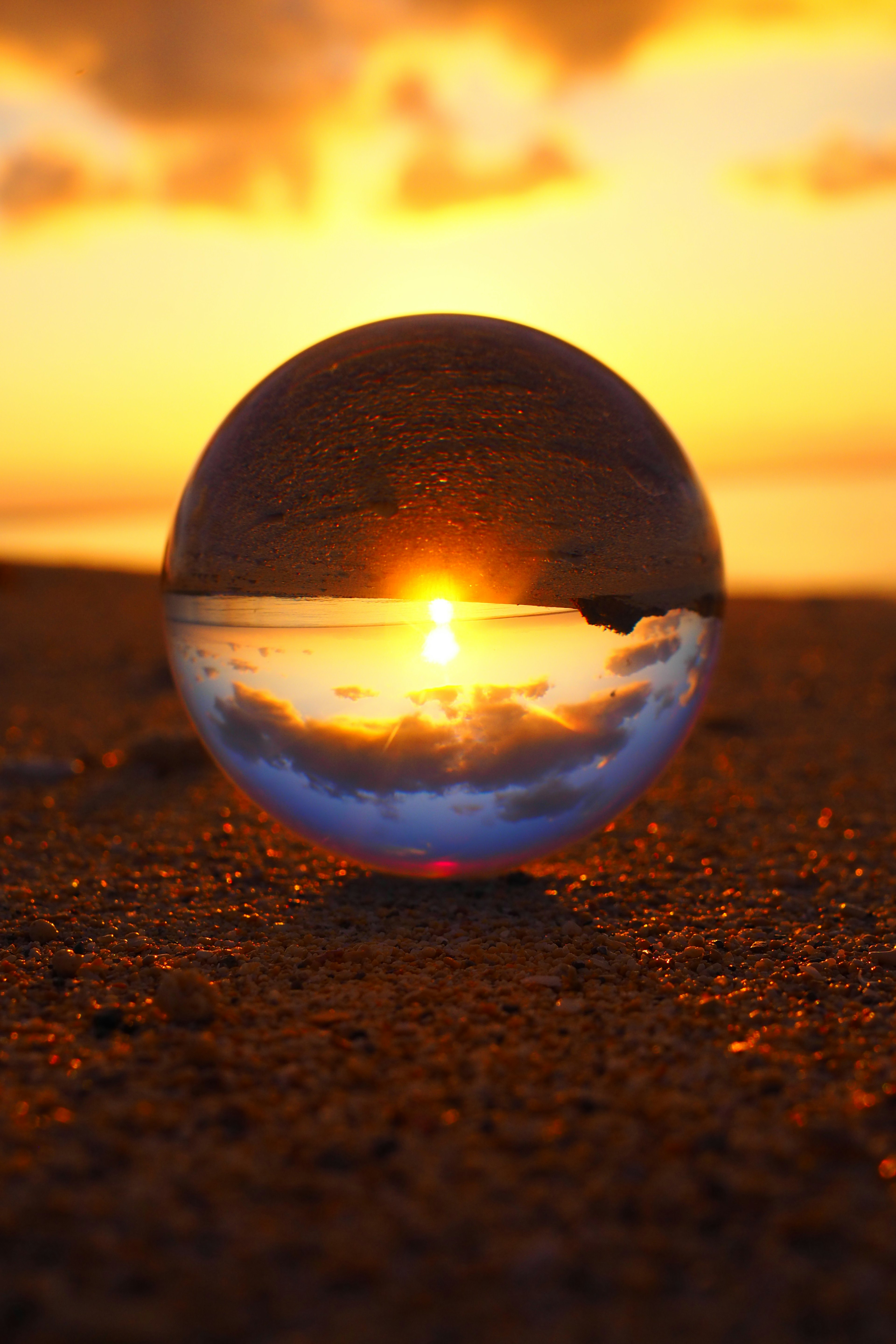 A crystal ball reflecting a sunset over the ocean