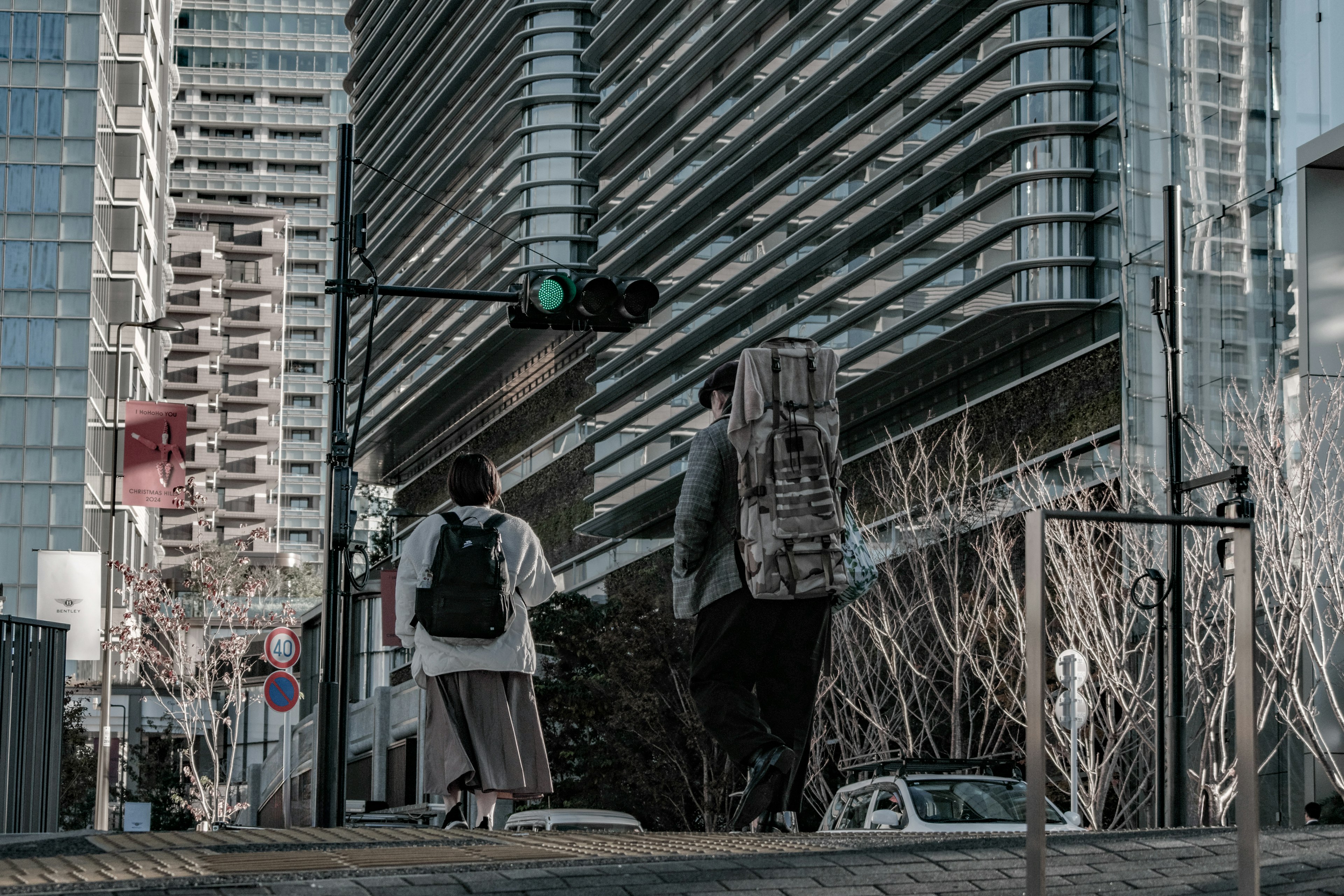 Dos personas caminando en un entorno urbano con un semáforo verde