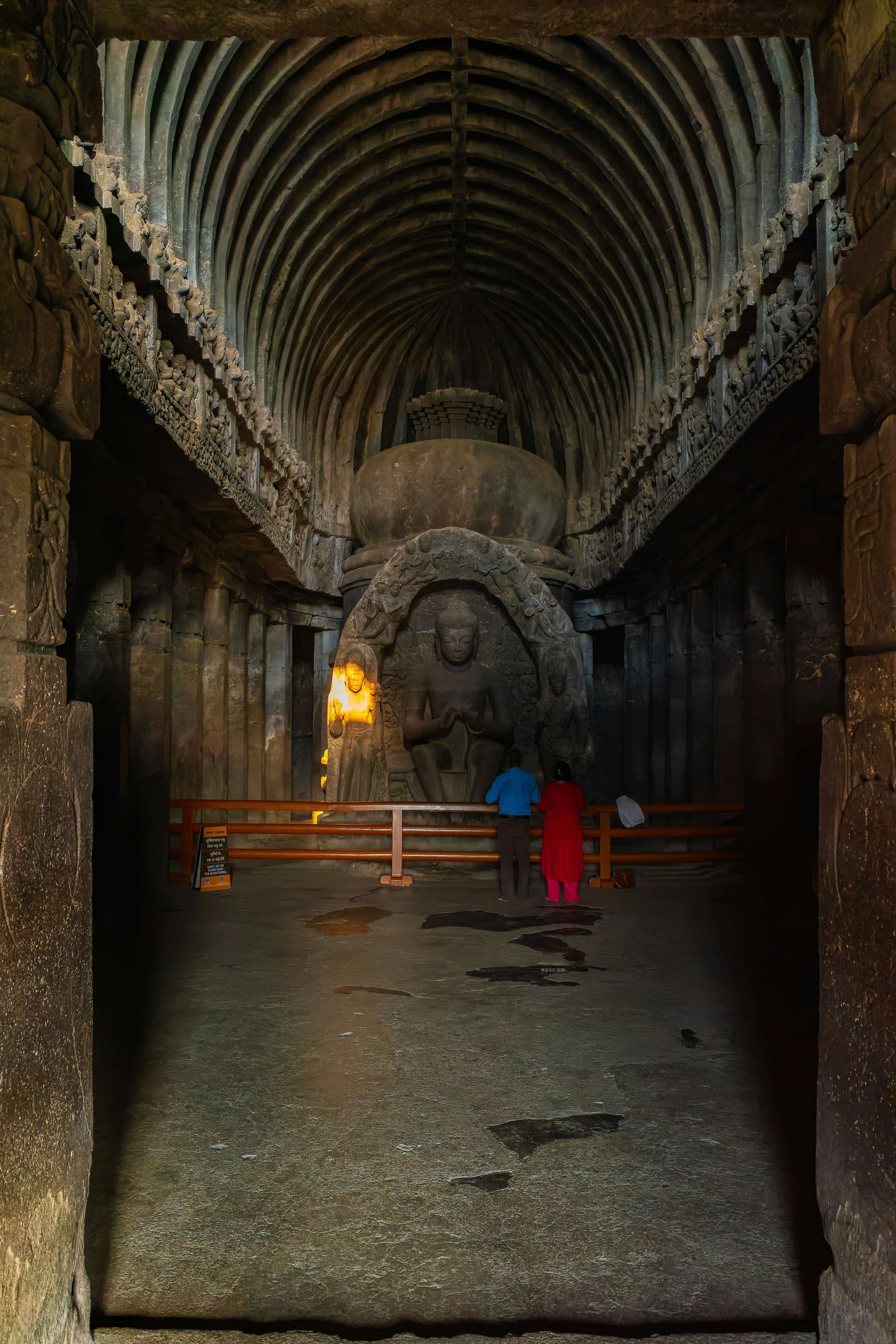 古代洞穴寺廟的內部 有雕刻的佛像和拱形天花板 還有信徒