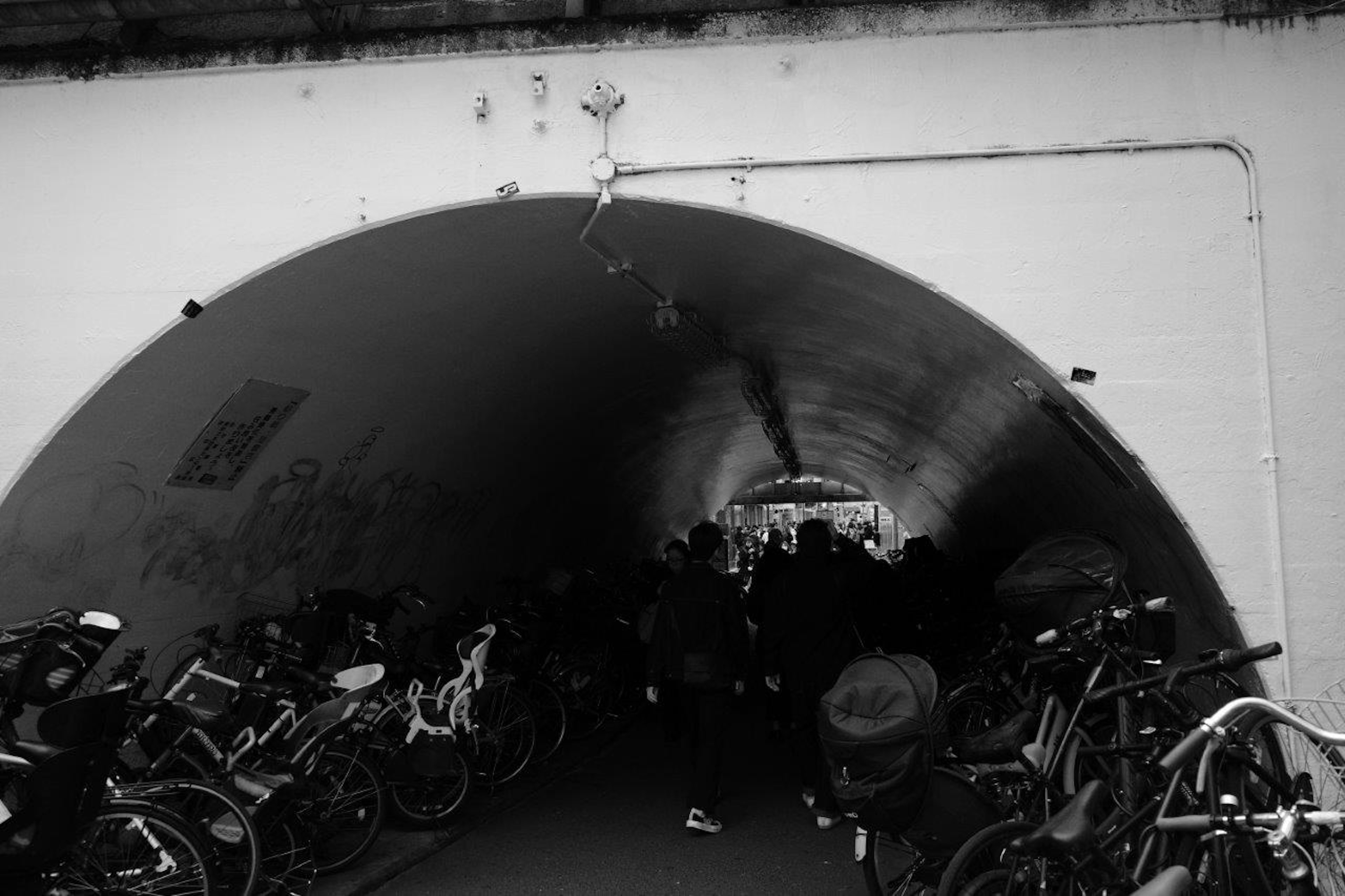 Black and white image of a tunnel with bicycles lined up