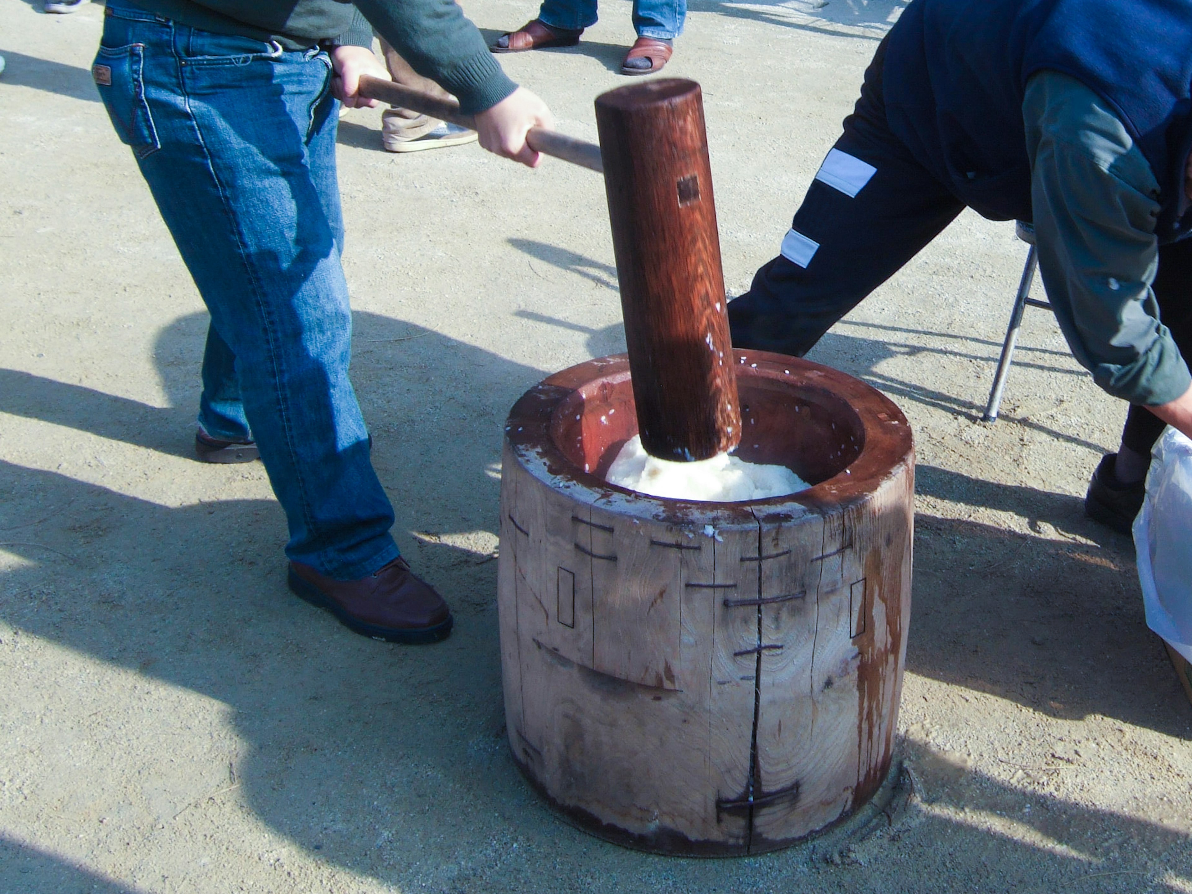 Scène de préparation de mochi avec un pilon et un mortier