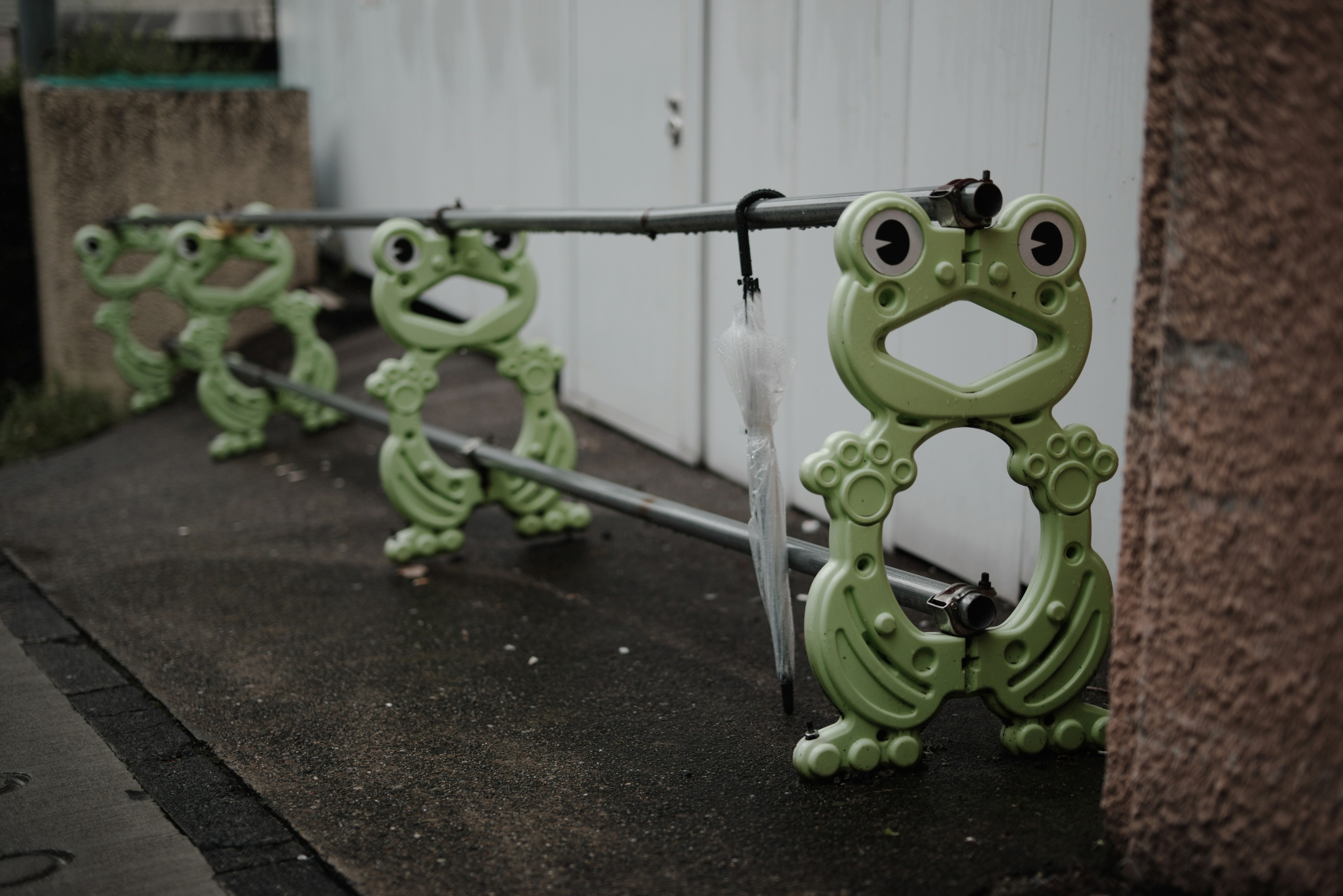 Row of green frog-shaped barriers on a street