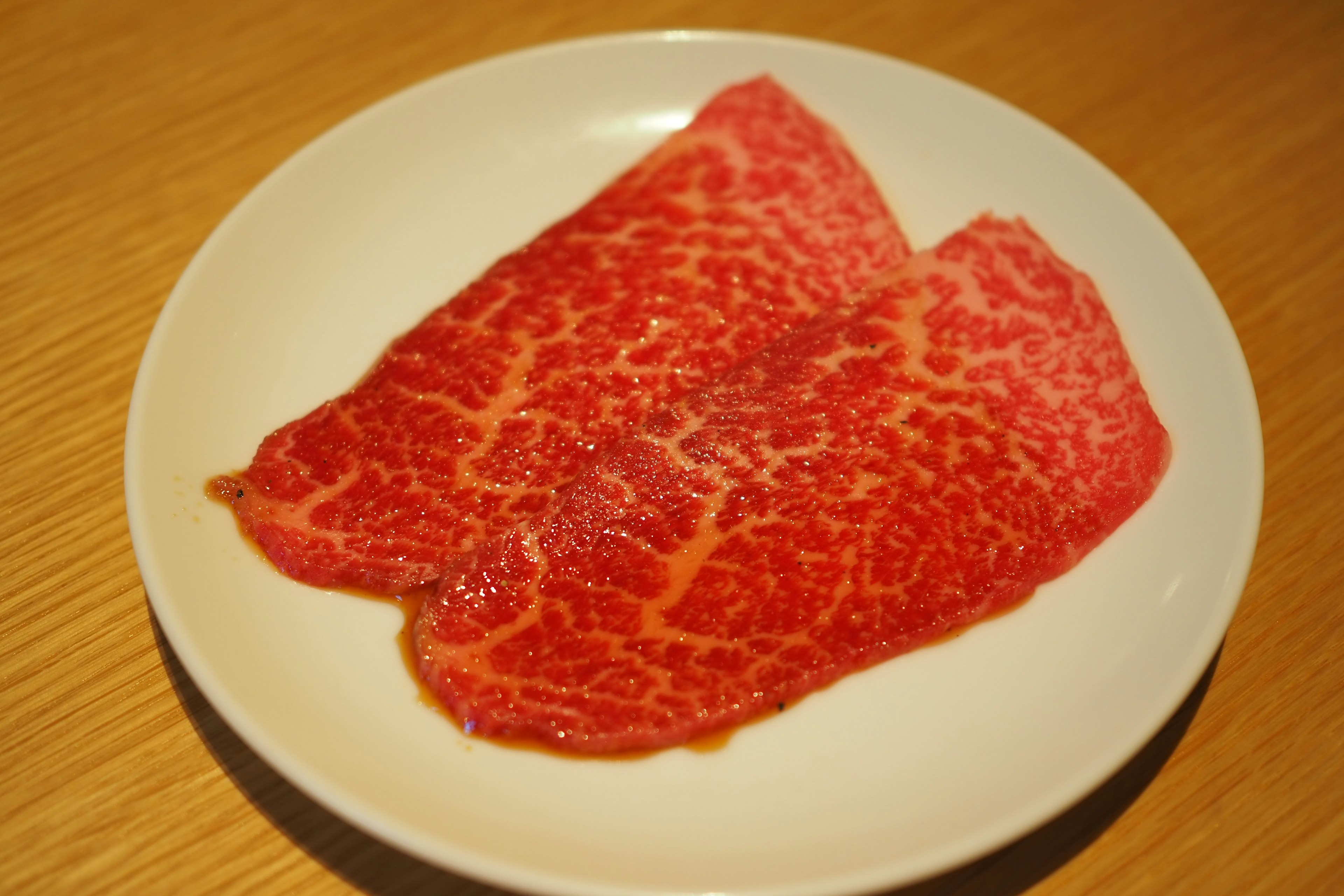 Sliced marbled Wagyu beef on a white plate