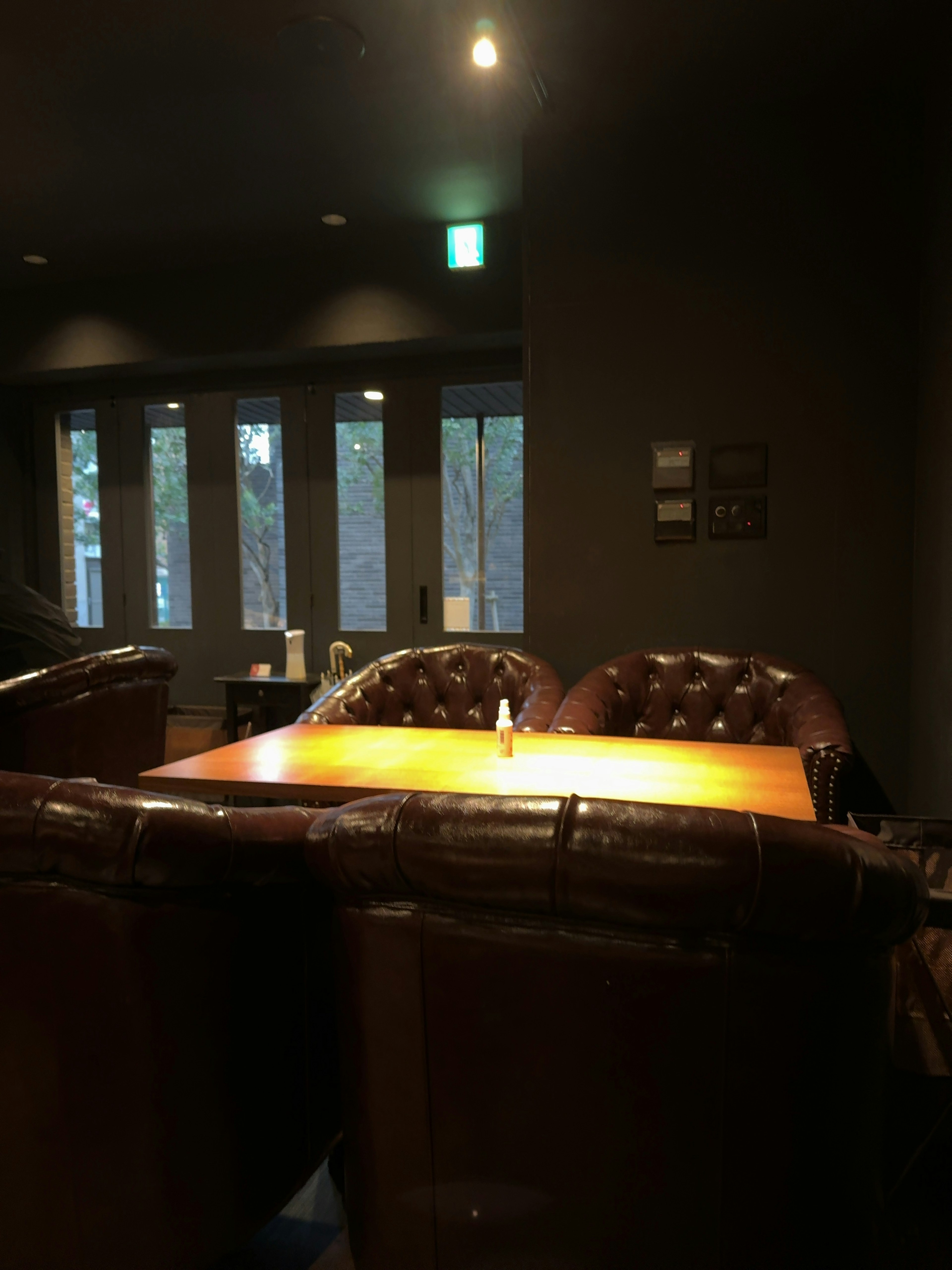 Cozy interior of a cafe featuring leather chairs and a wooden table with soft lighting