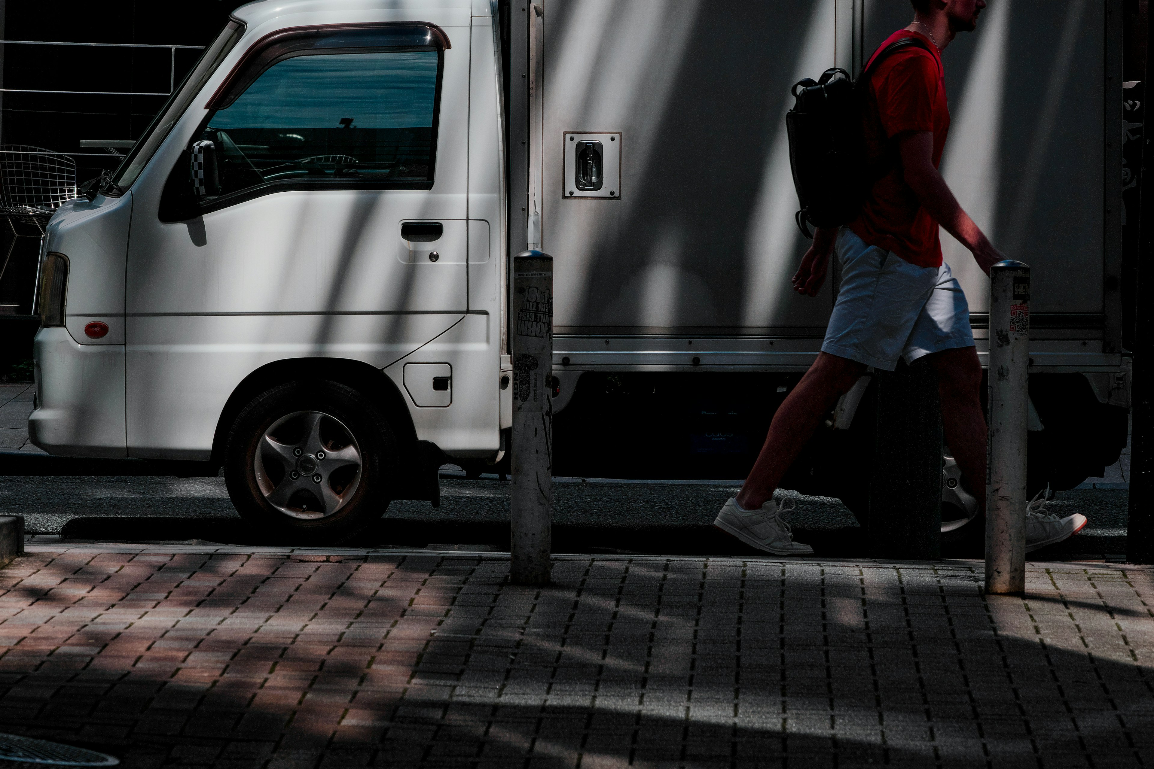 Silhouette di una persona che cammina accanto a un camion bianco