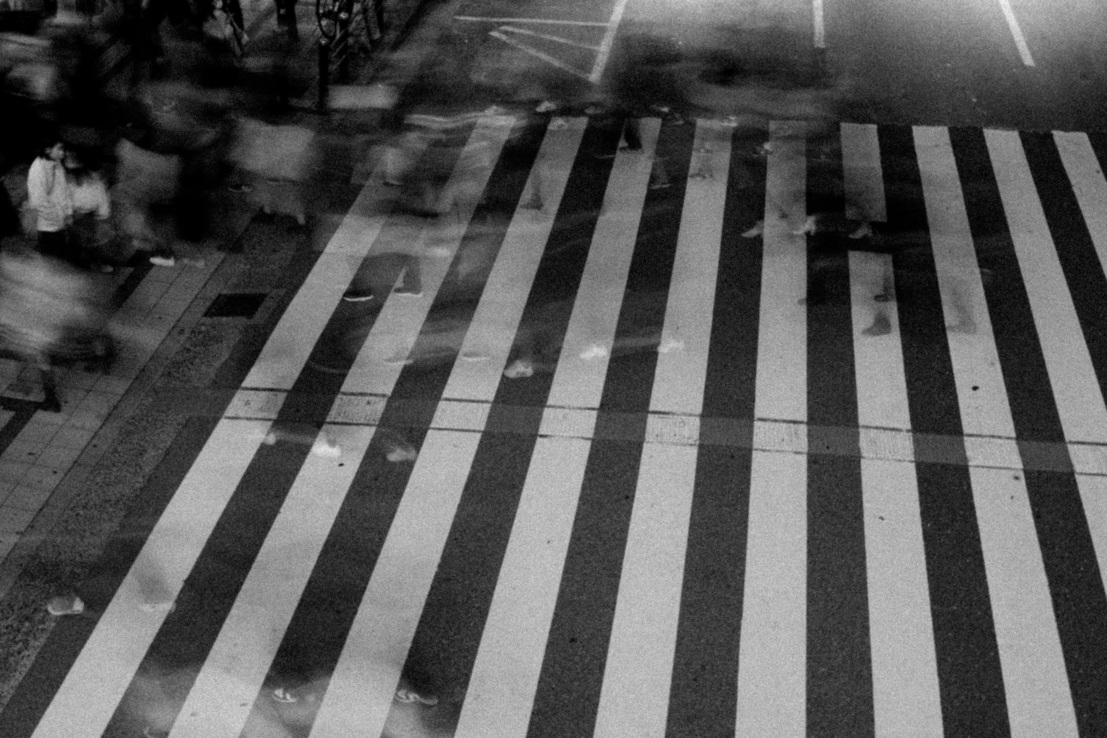 Black and white striped crosswalk with blurred motion of pedestrians at night