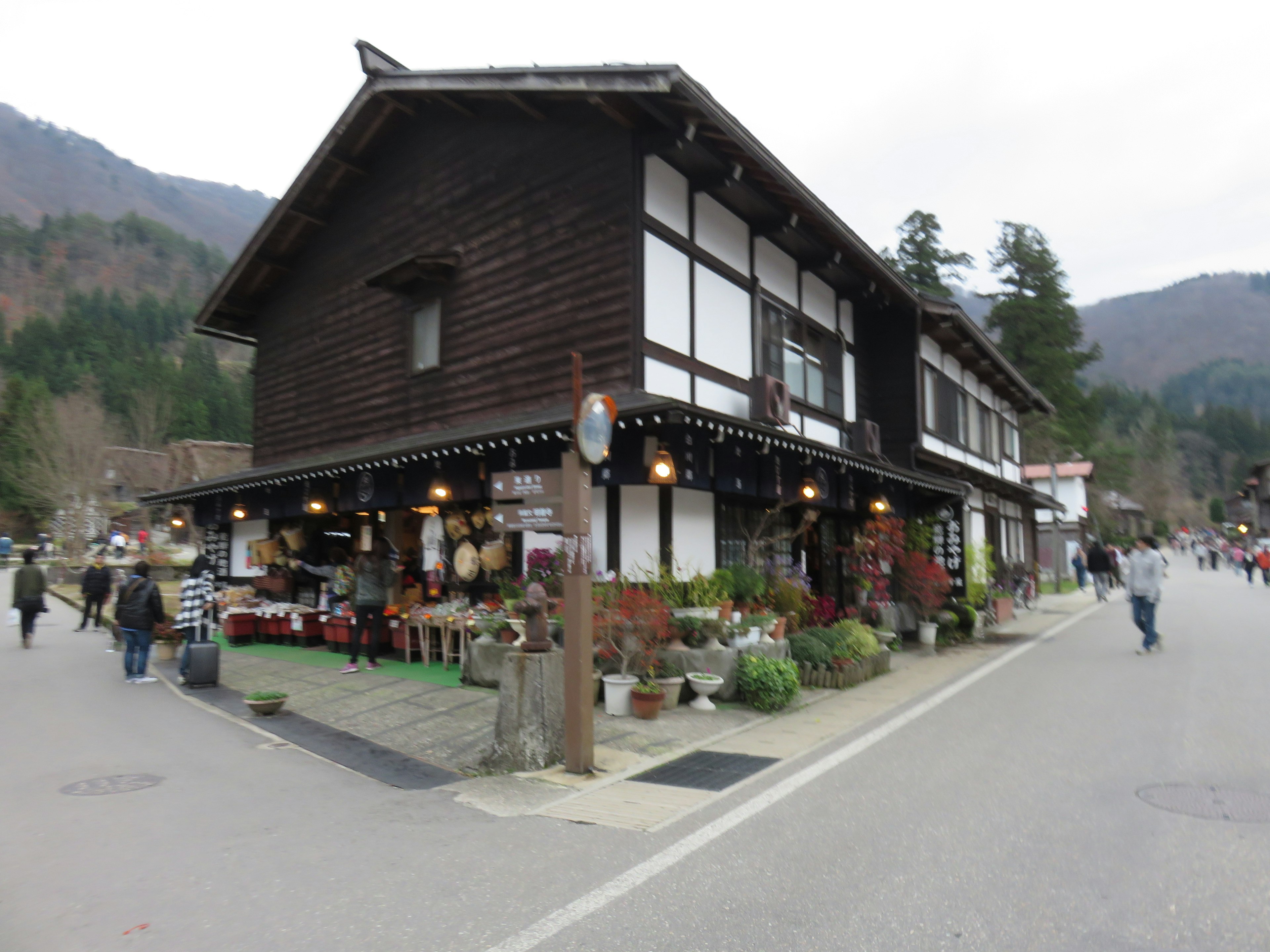 Traditionelles Holzgebäude mit Geschäften und Fußgängern