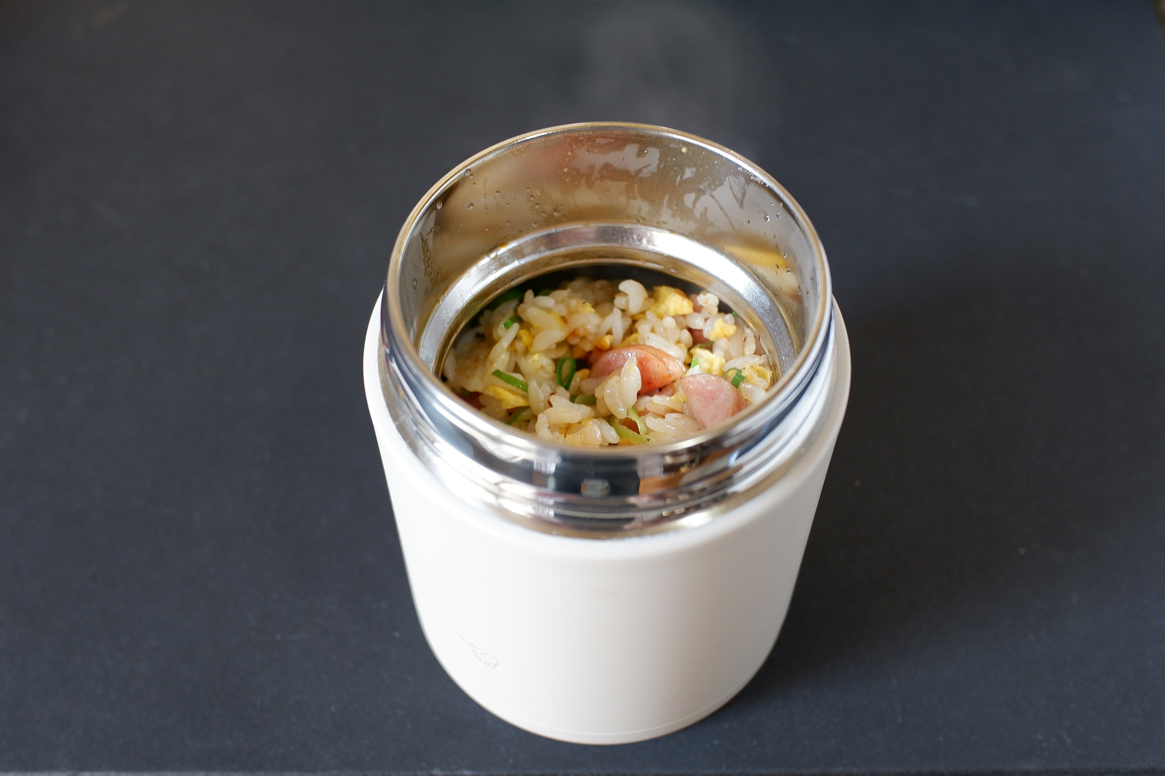 White insulated container filled with a hearty dish