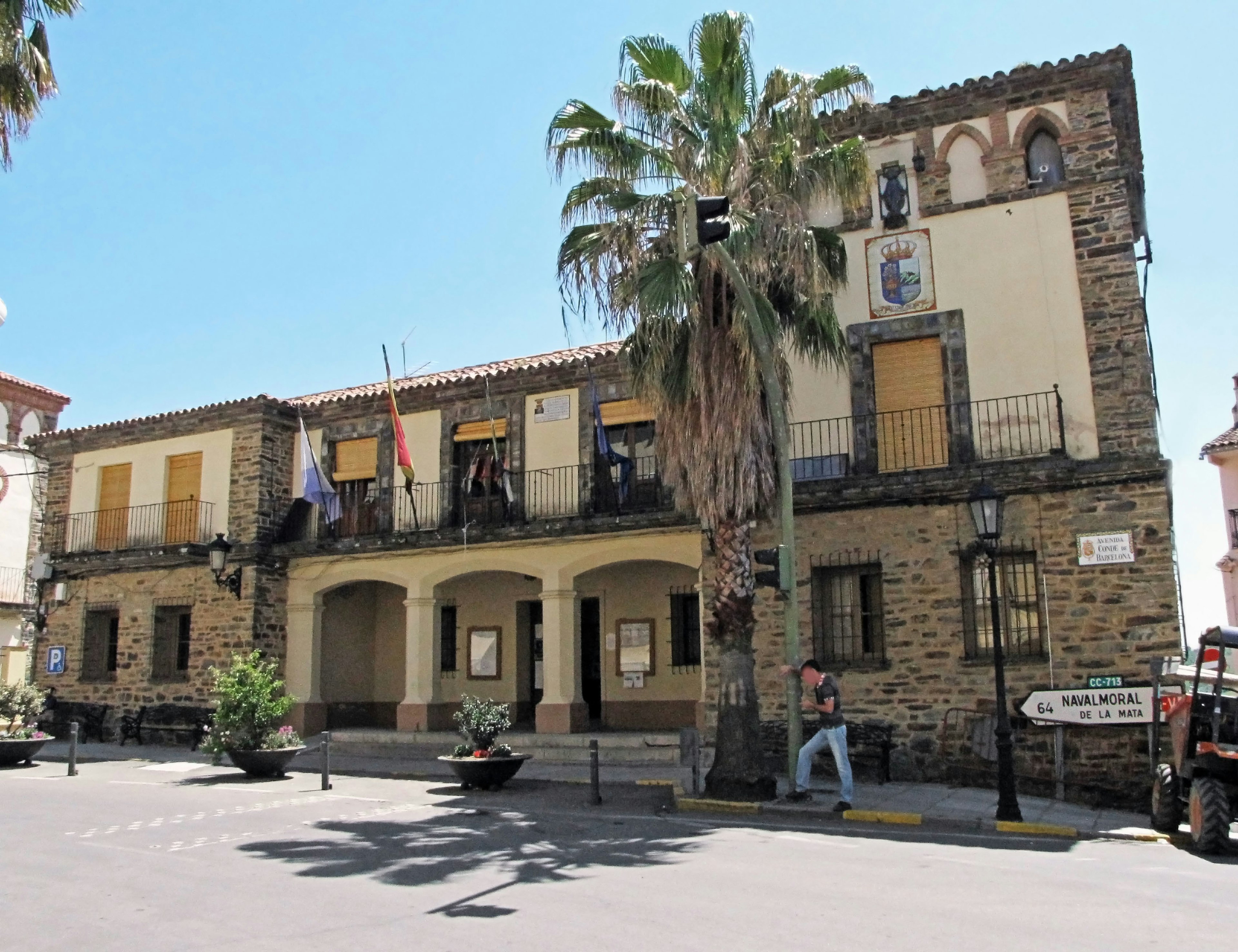 Historic stone town hall building with palm trees