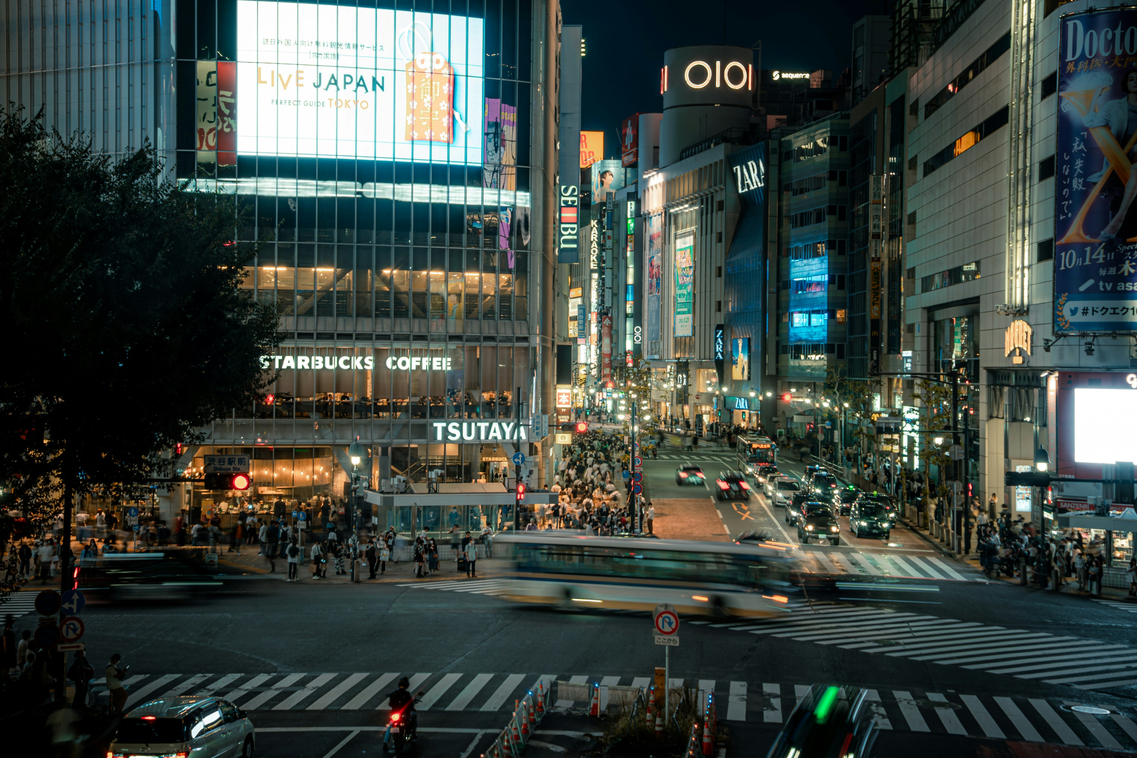 Busy intersection in Shibuya Tokyo at night with bright neon lights