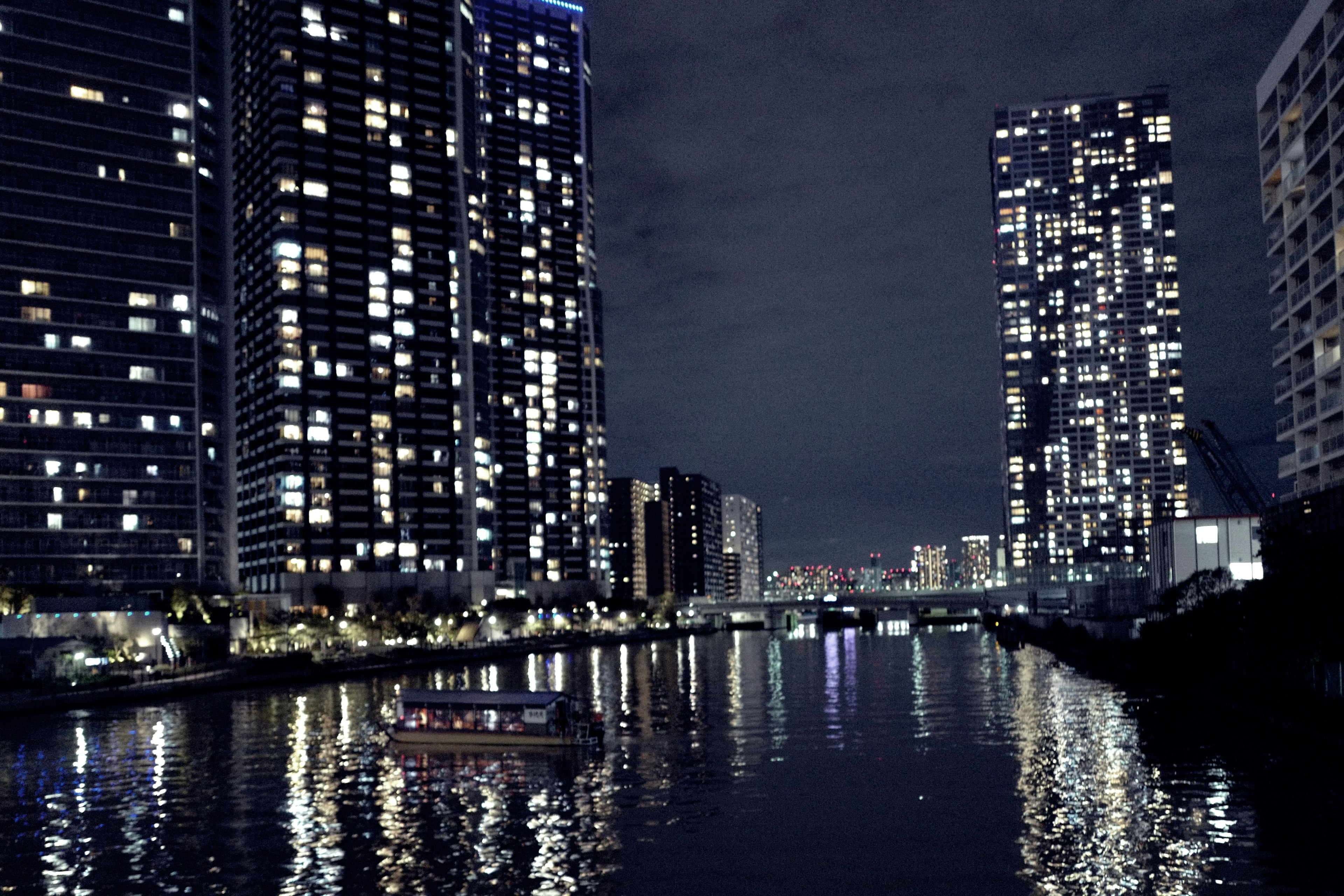 Paisaje urbano nocturno con rascacielos reflejados en el agua