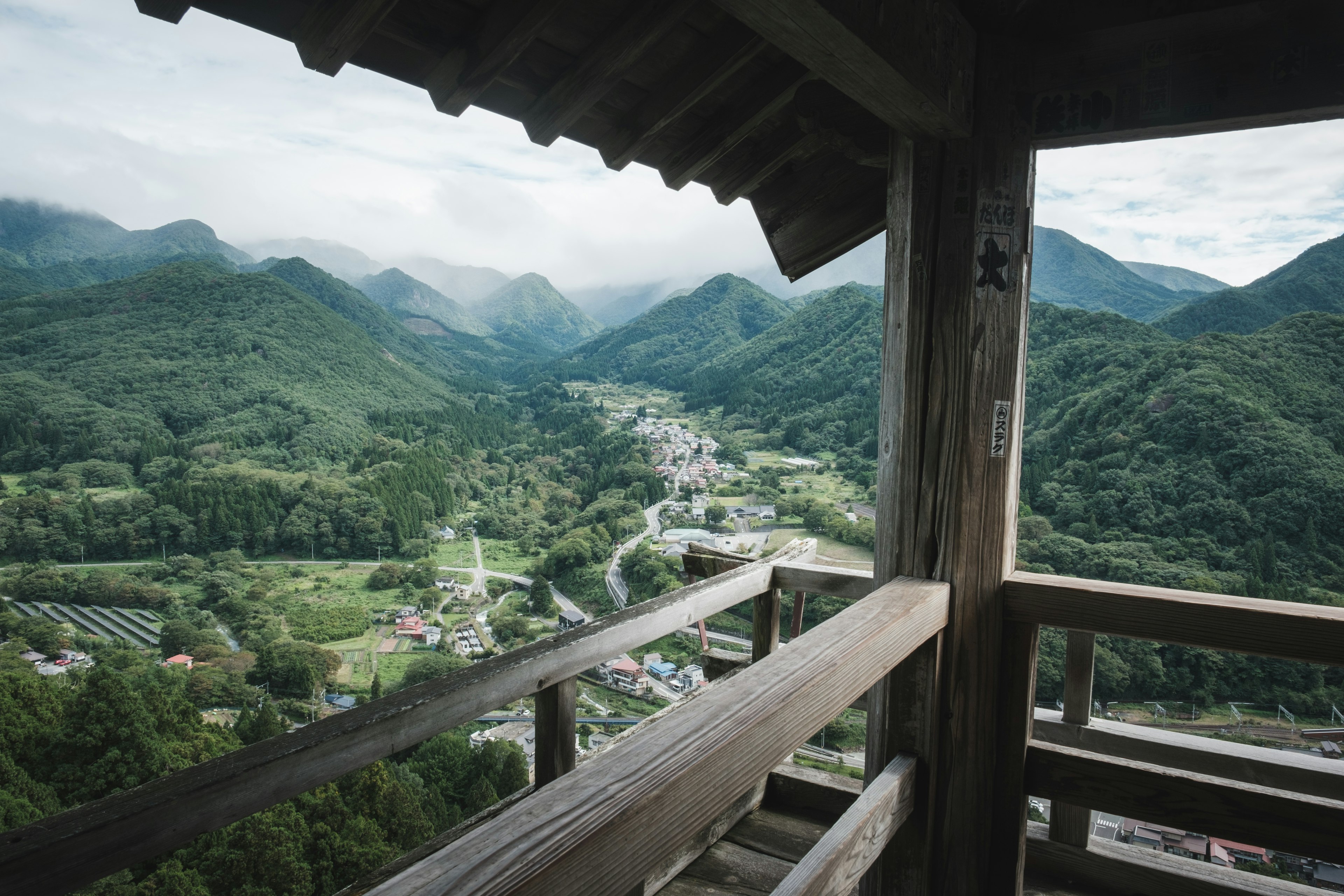 Holzturm mit Blick auf Berge und Dorf