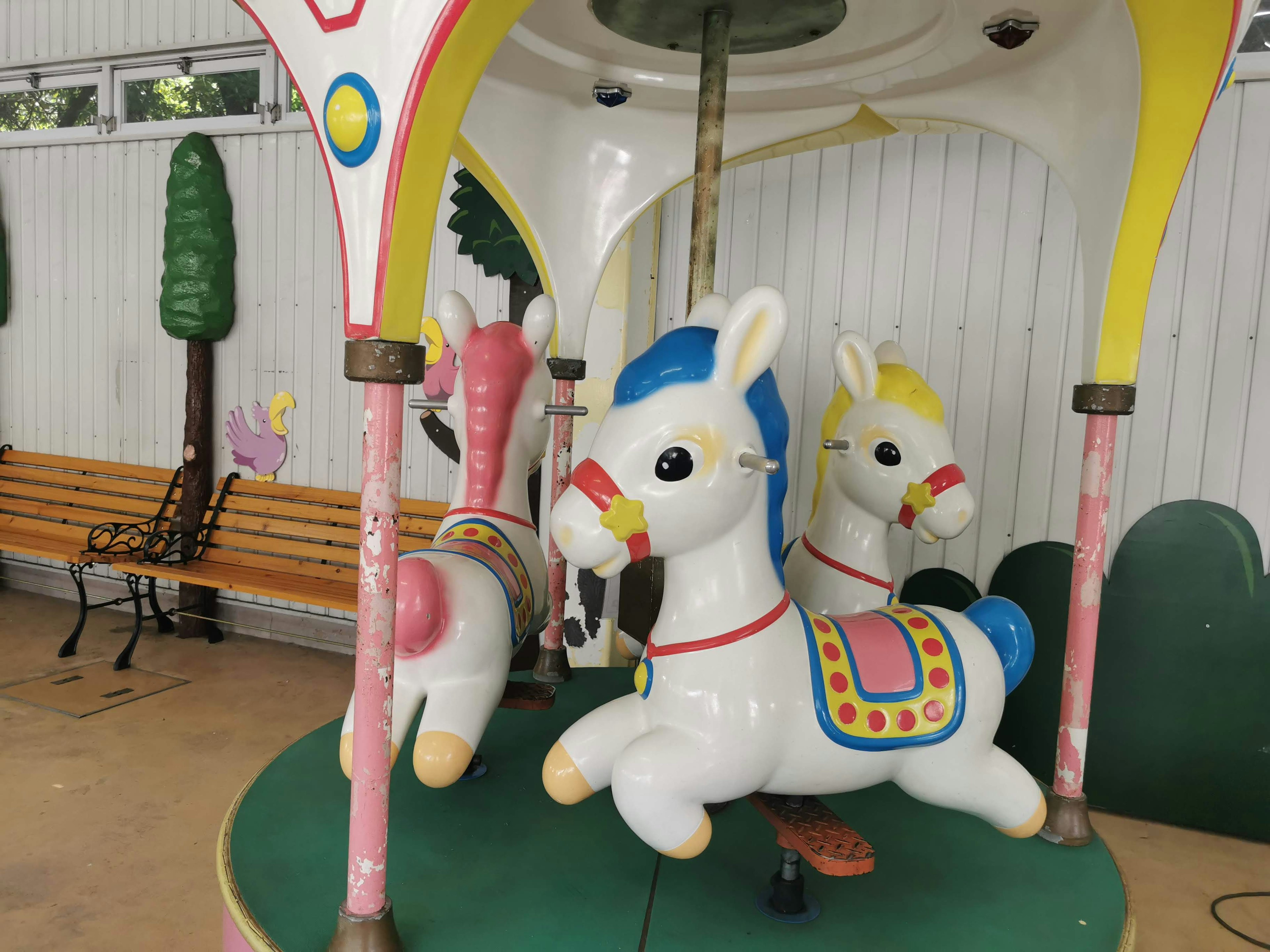 Colorful carousel with white horse figures