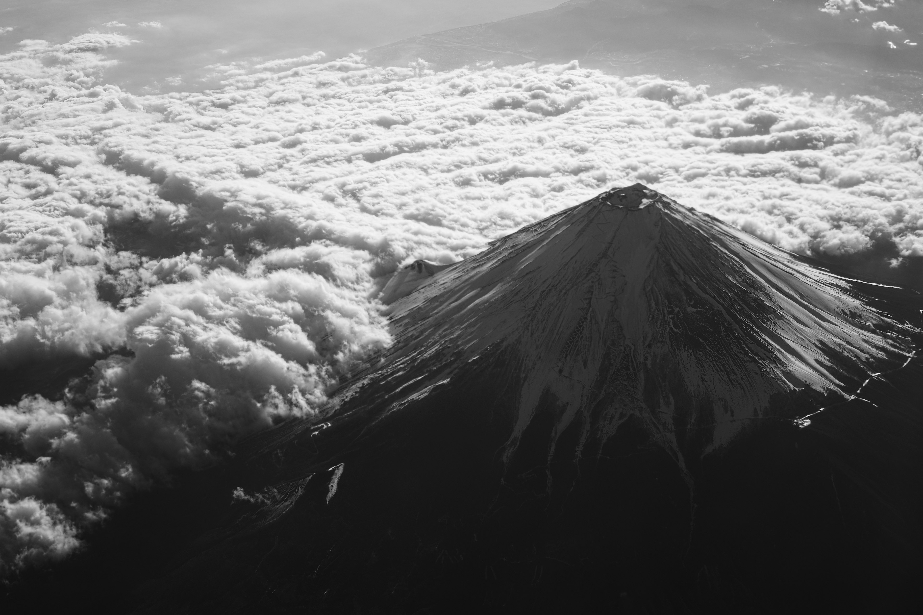 Vista aérea del monte Fuji emergiendo sobre un mar de nubes en blanco y negro