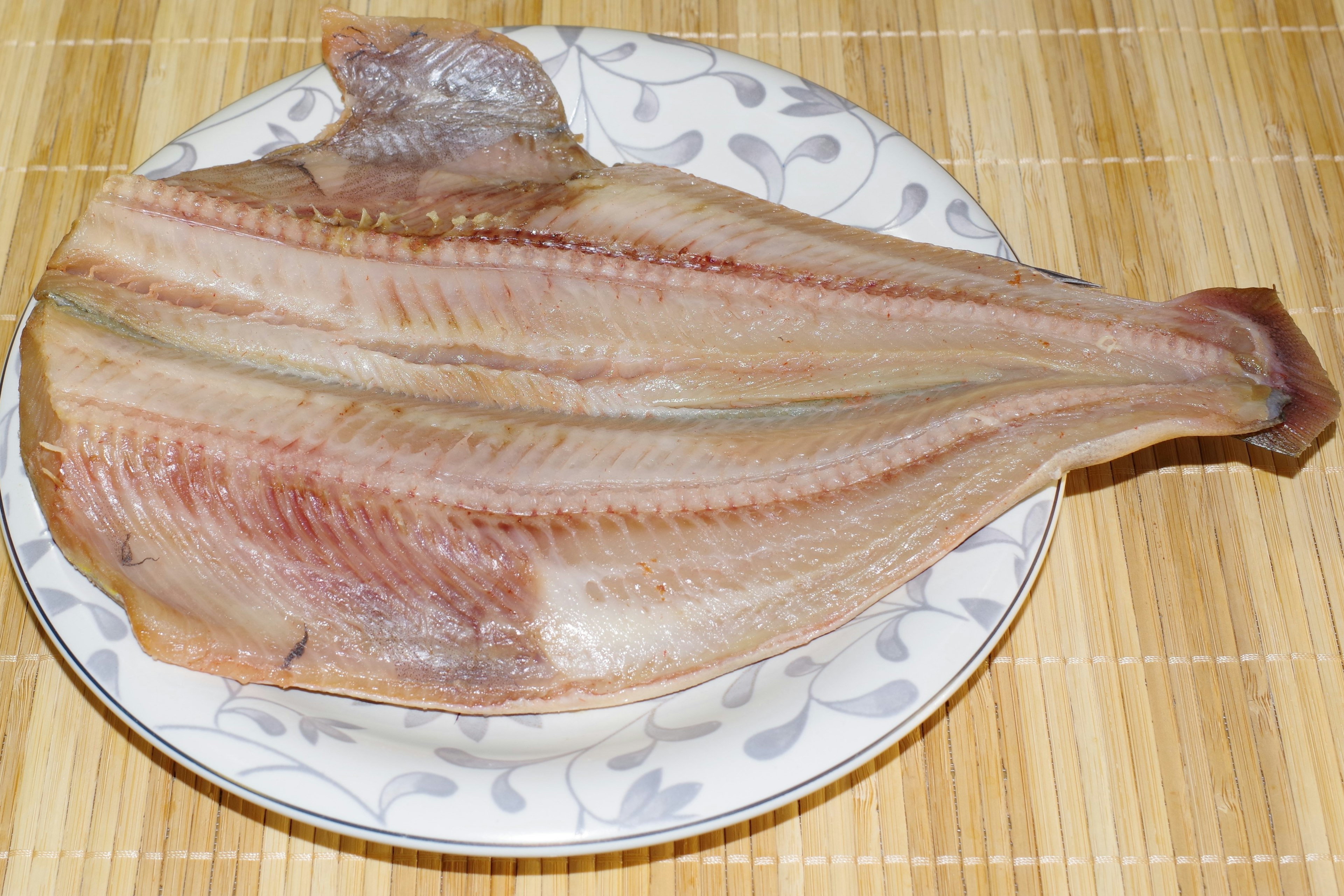 Filete de pescado seco plano en un plato decorativo