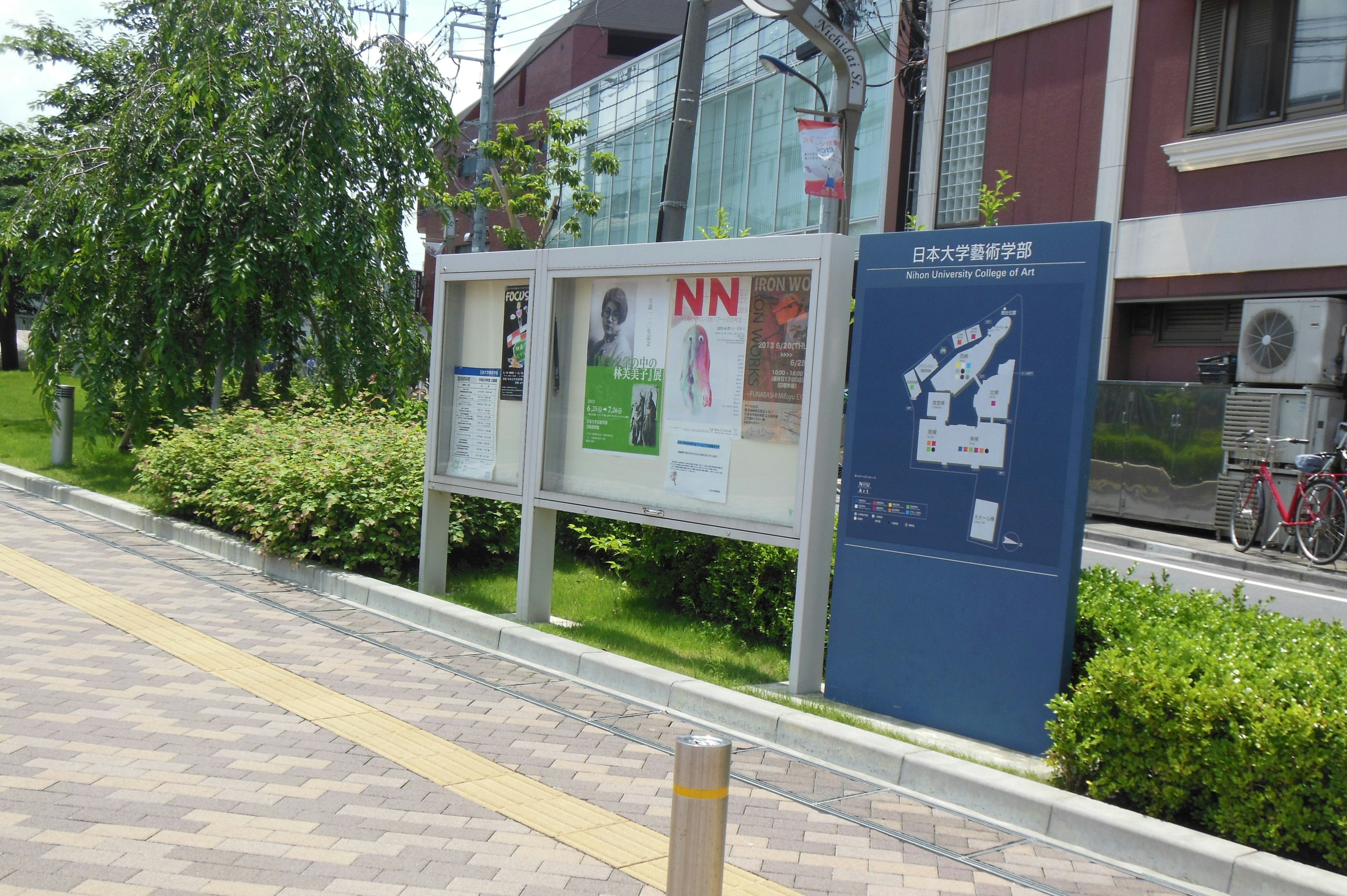 街の案内板と緑の植栽がある風景