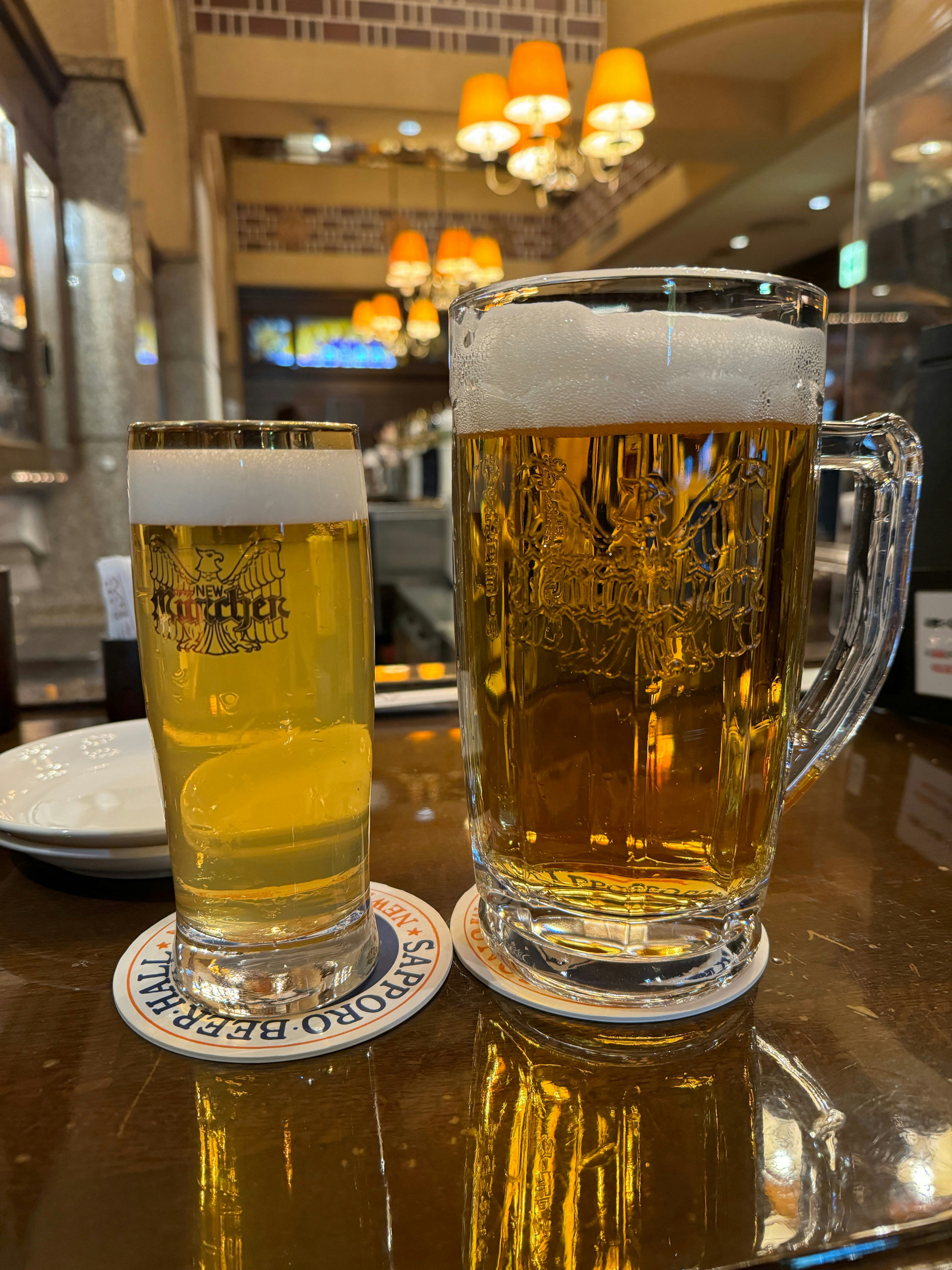 Un petit verre de bière et une grande chope de bière côte à côte