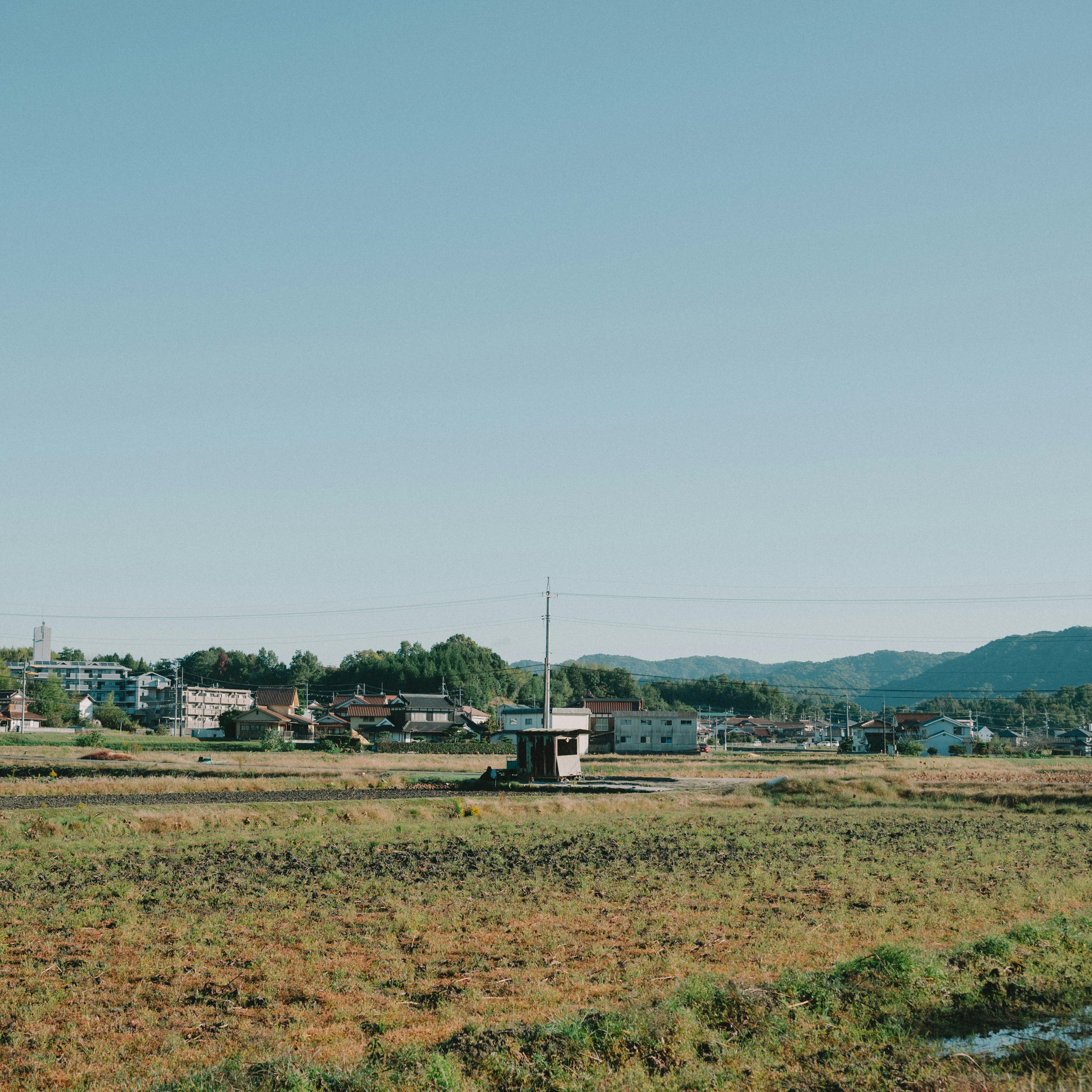 青空の下の田園風景と小屋の風景