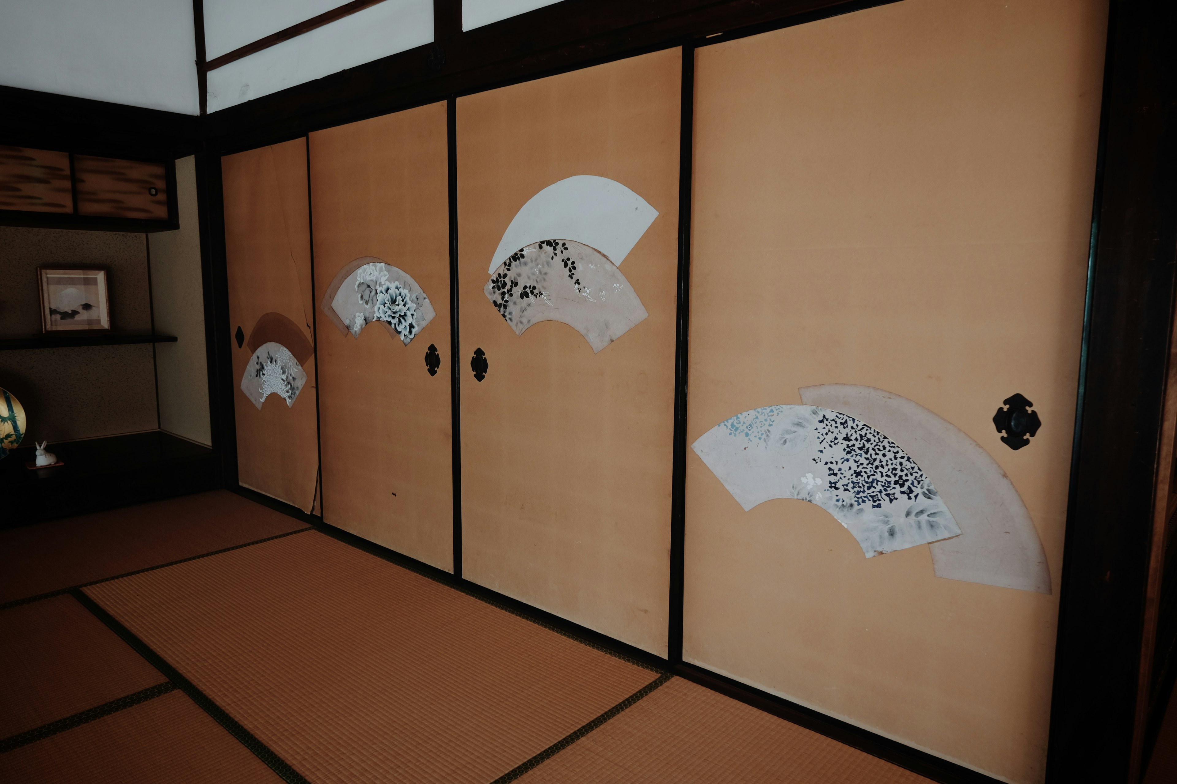 Interior of a traditional Japanese room with fan-patterned sliding doors and tatami flooring