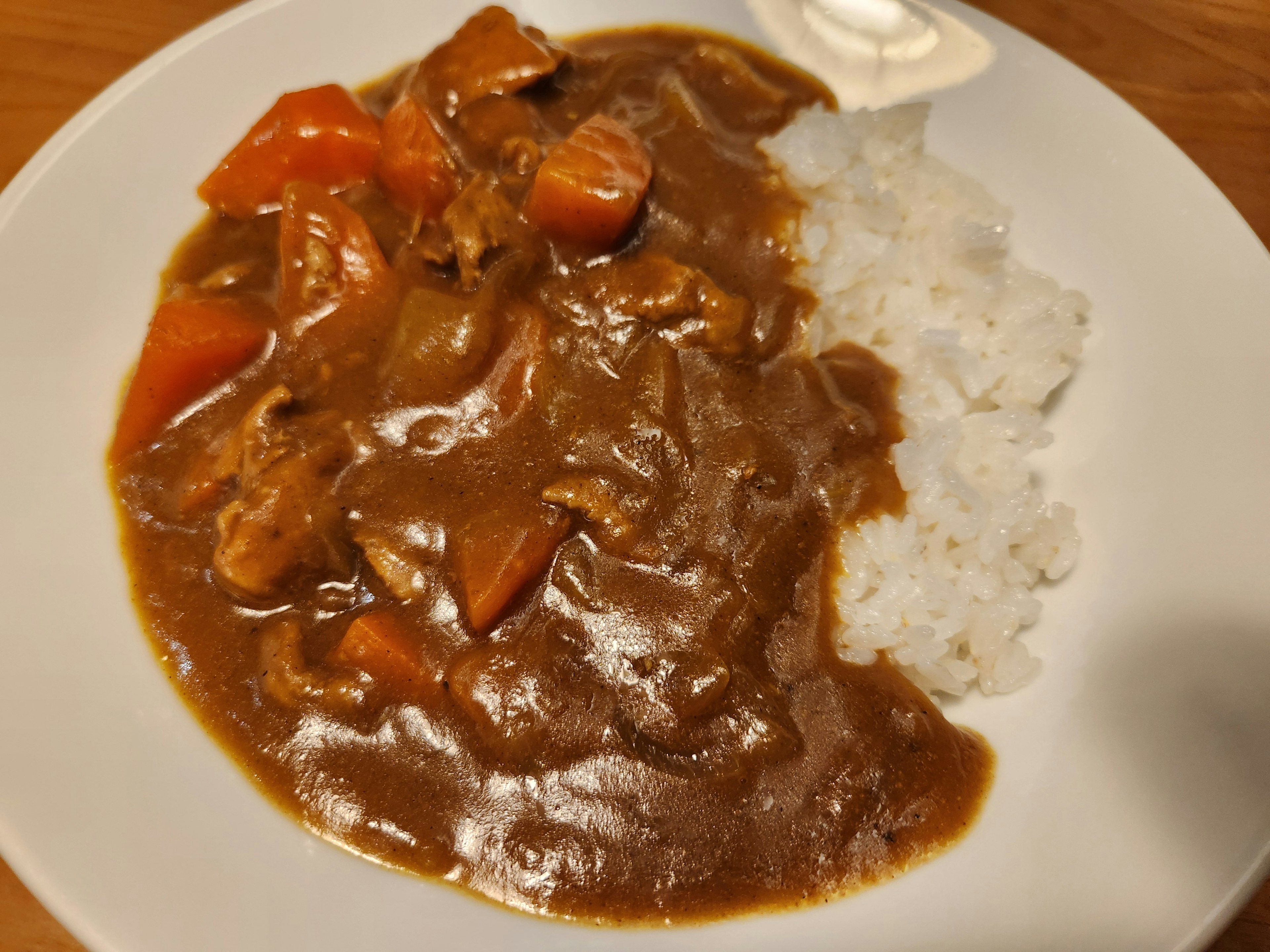 맛있는 카레밥이 흰 접시에 담겨 있습니다