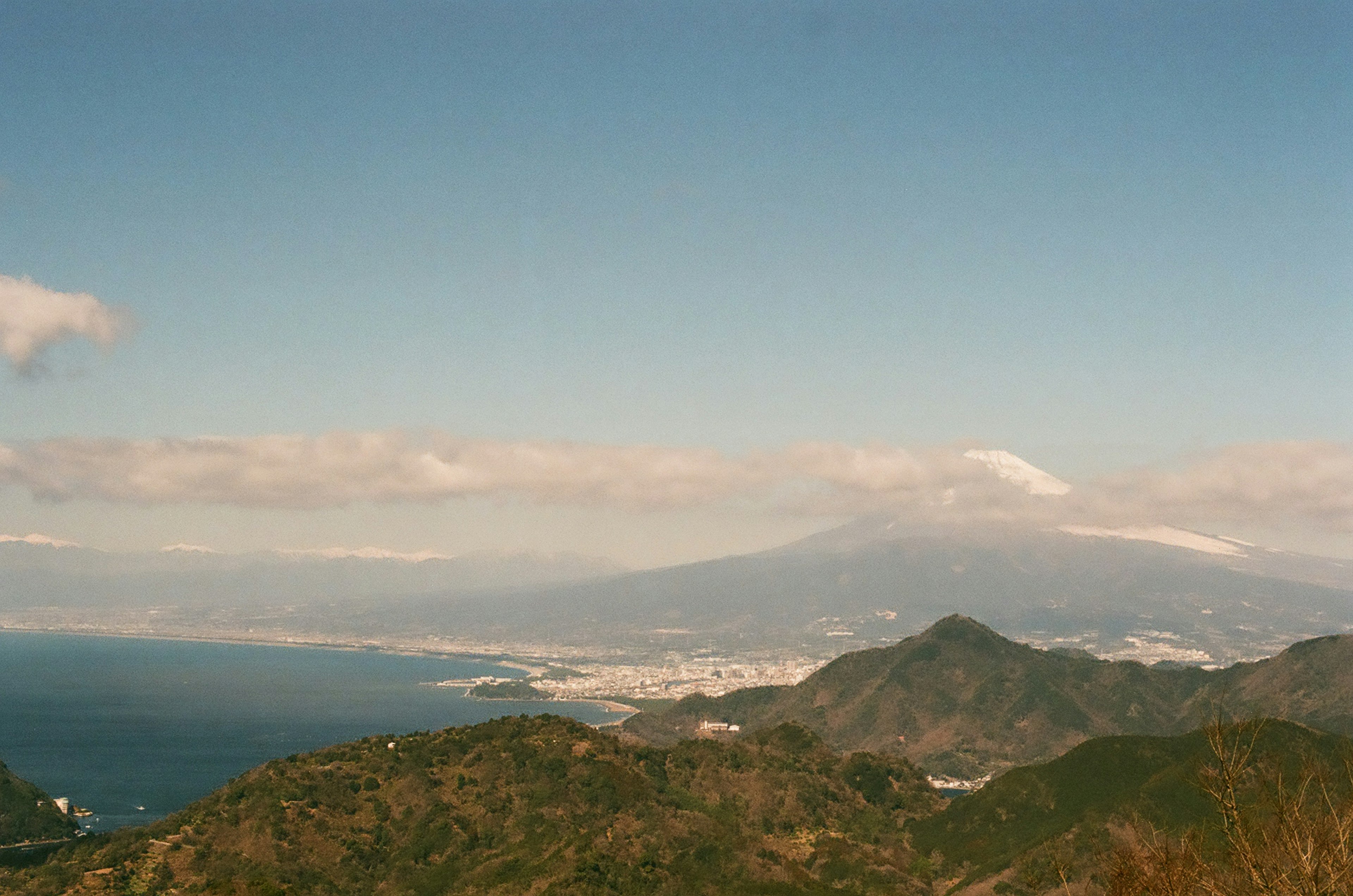 青い空と雲の下に広がる山と海の景色