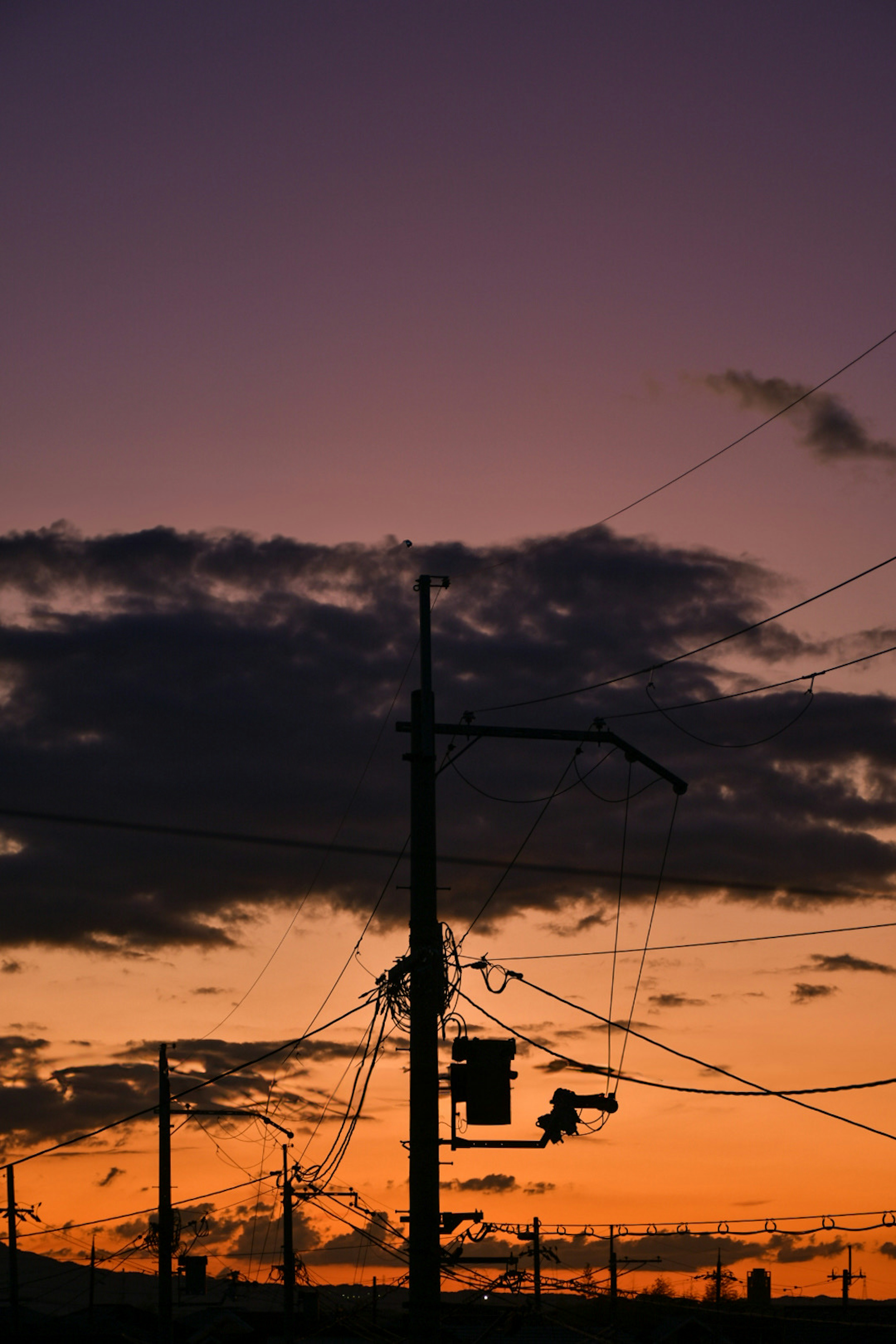 夕陽下電線和電杆的輪廓