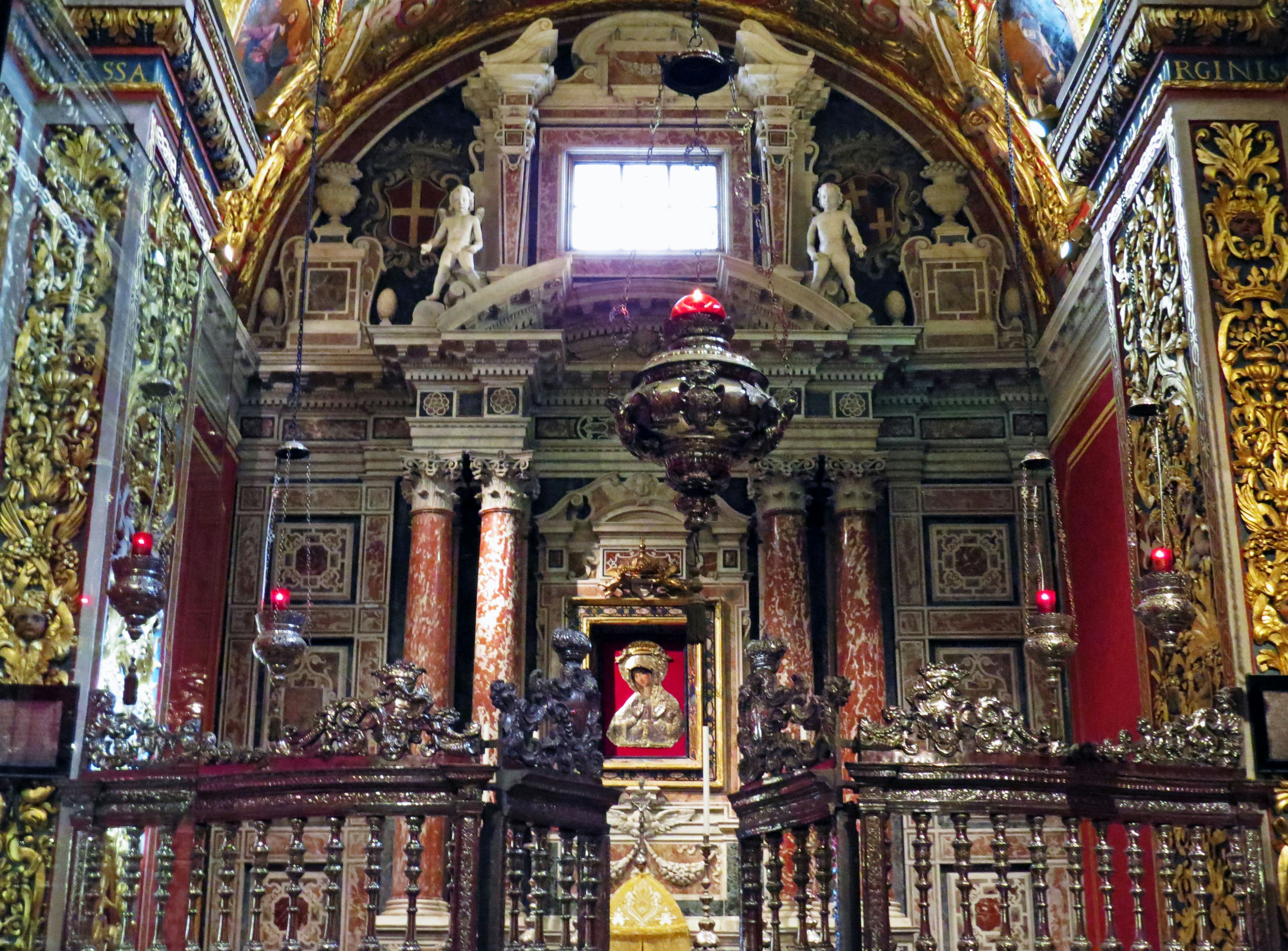 Interior gereja yang didekorasi dengan ornamen emas lilin merah dan langit-langit megah