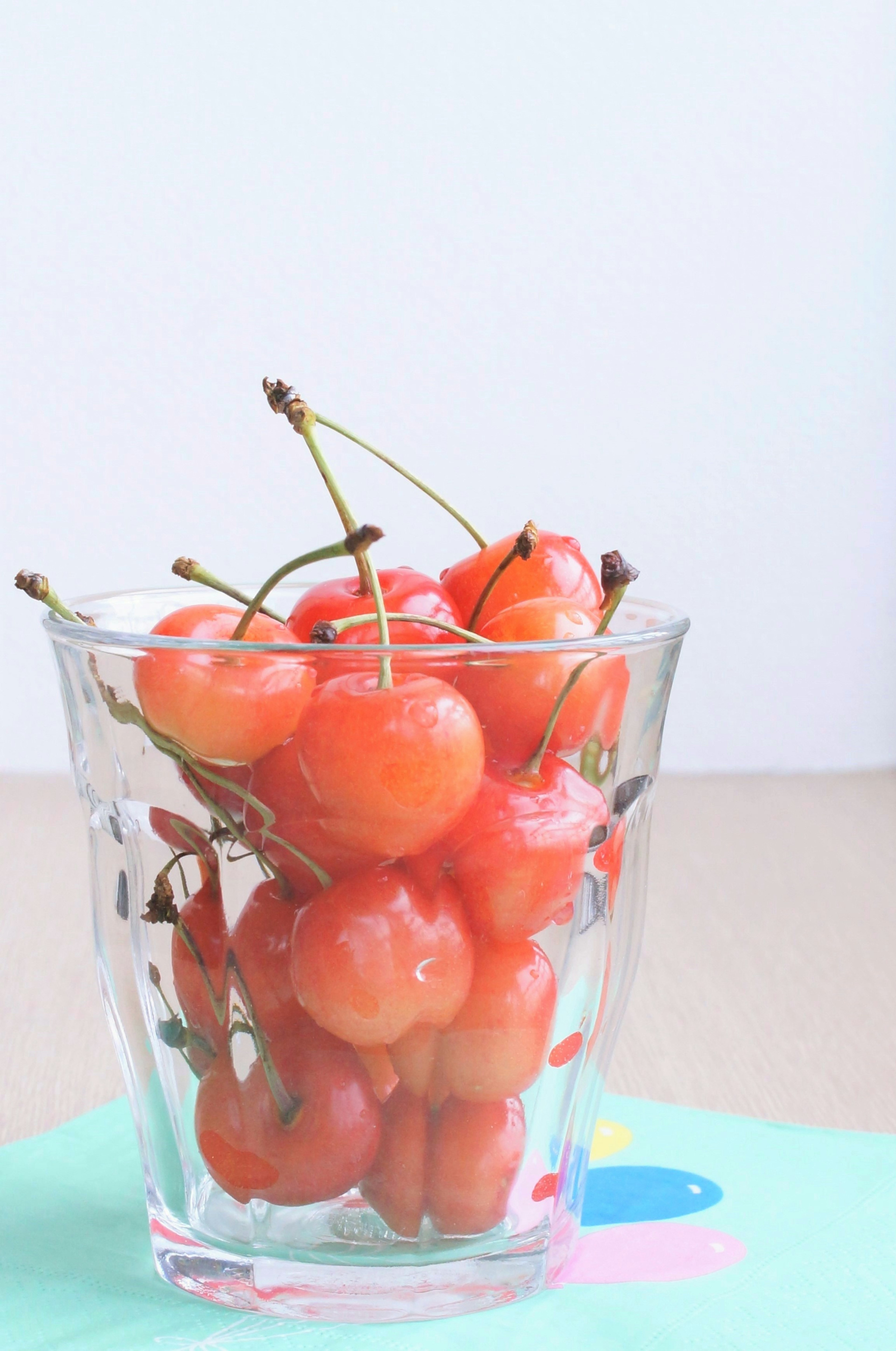 Eine Gruppe roter Kirschen in einem klaren Glas