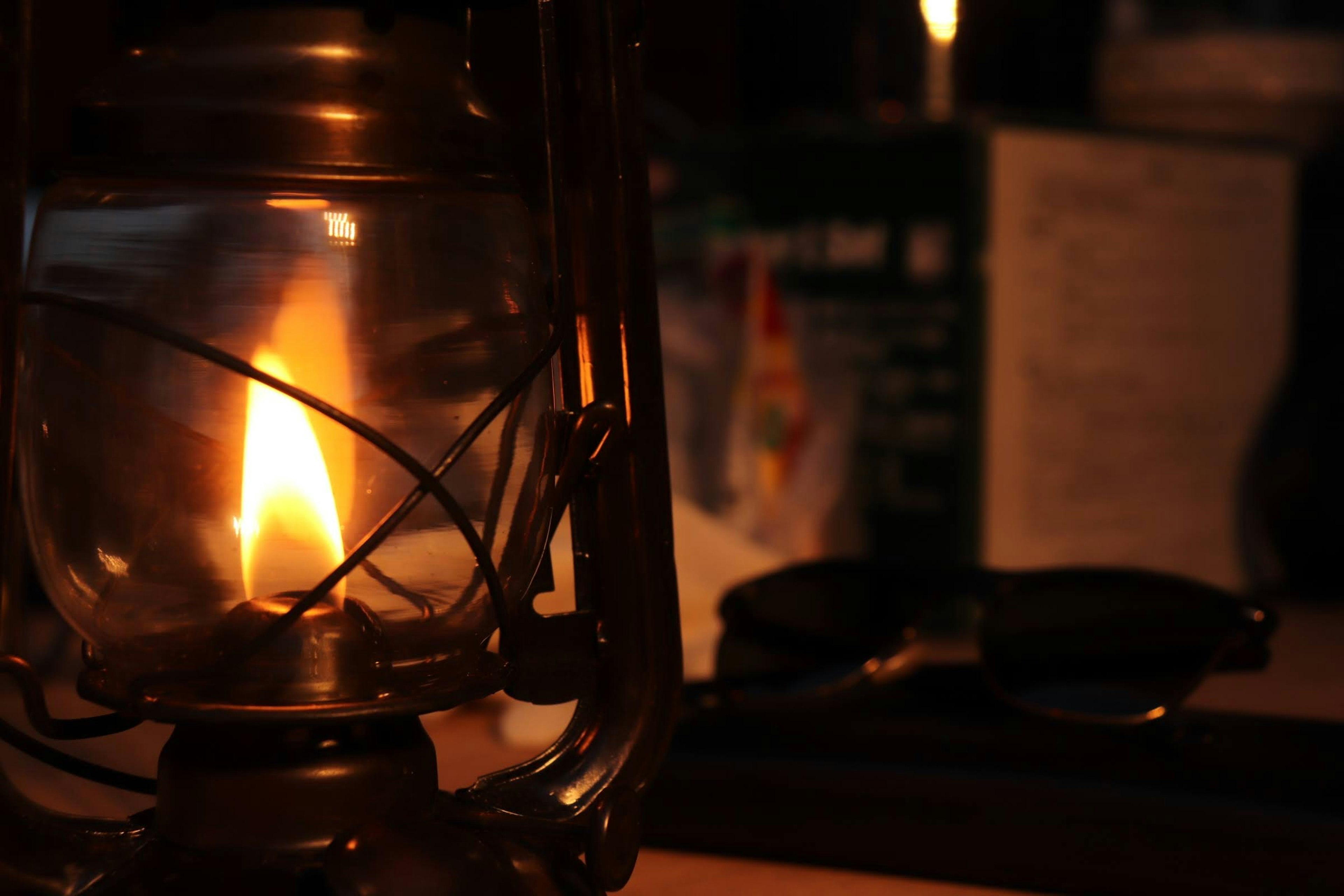 Oil lamp emitting warm light with dark background