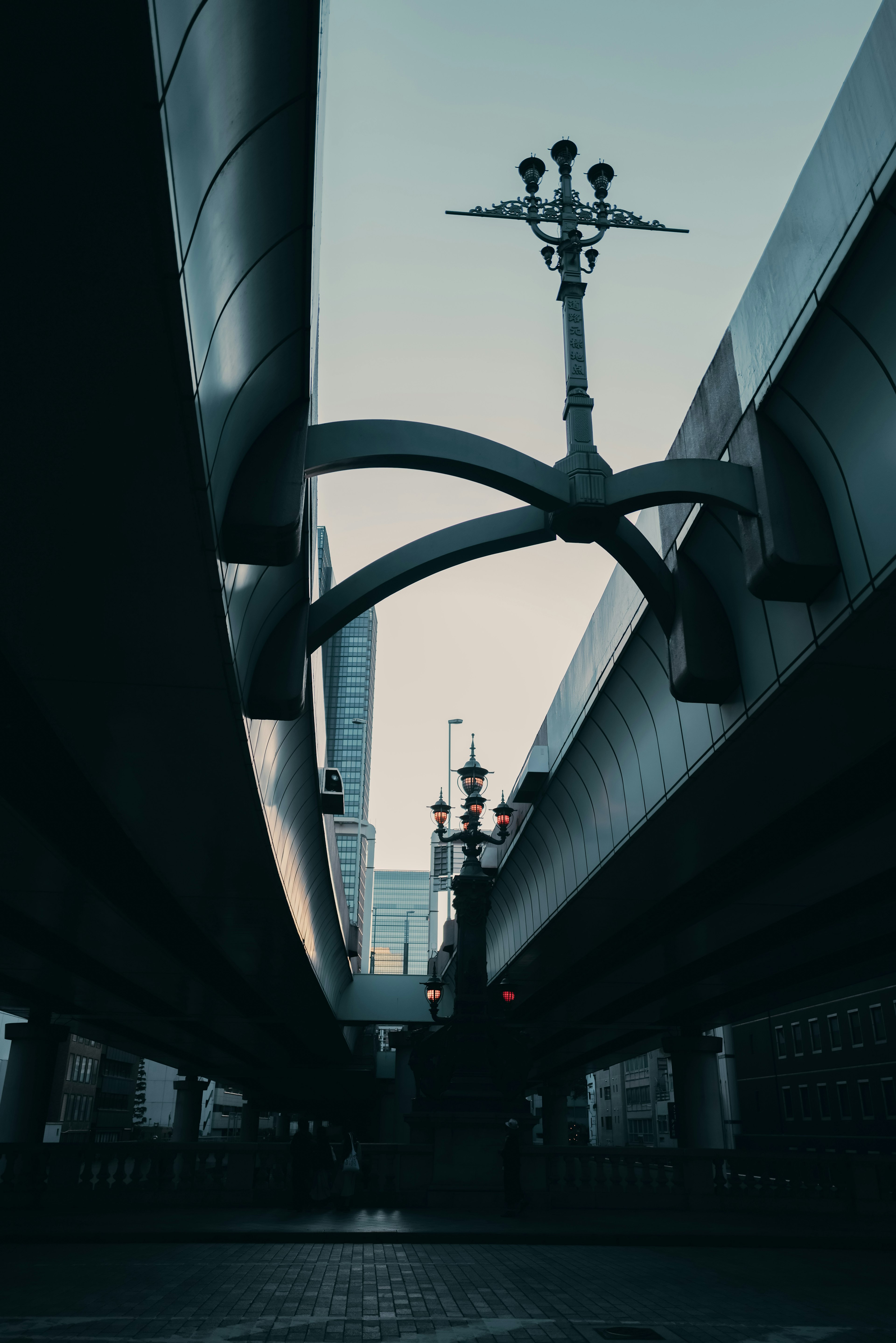 Foto einer Struktur von unten unter einer Überführung mit Stahlträgern und Straßenlaternen