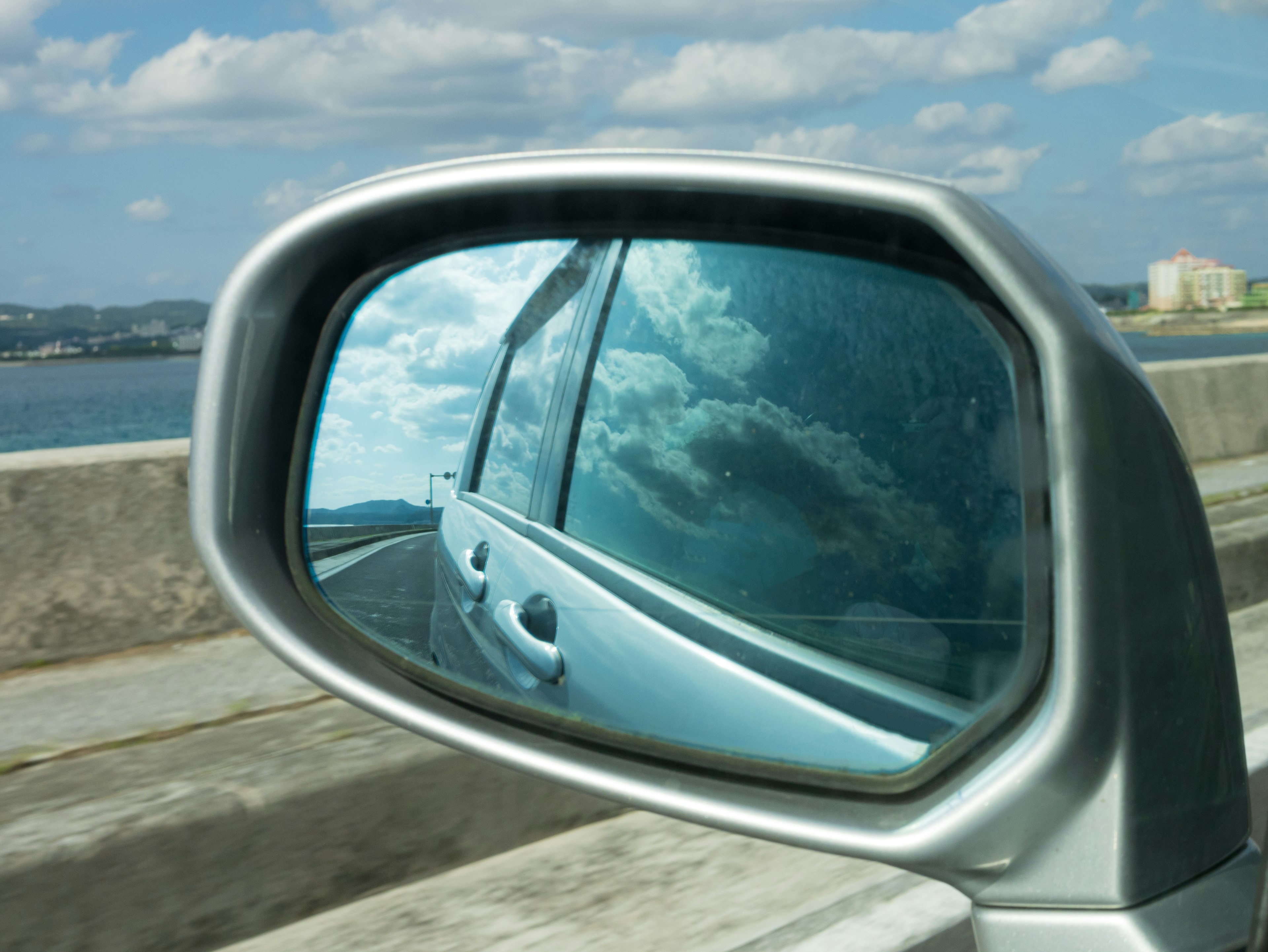 Rétroviseur montrant un ciel bleu et des nuages