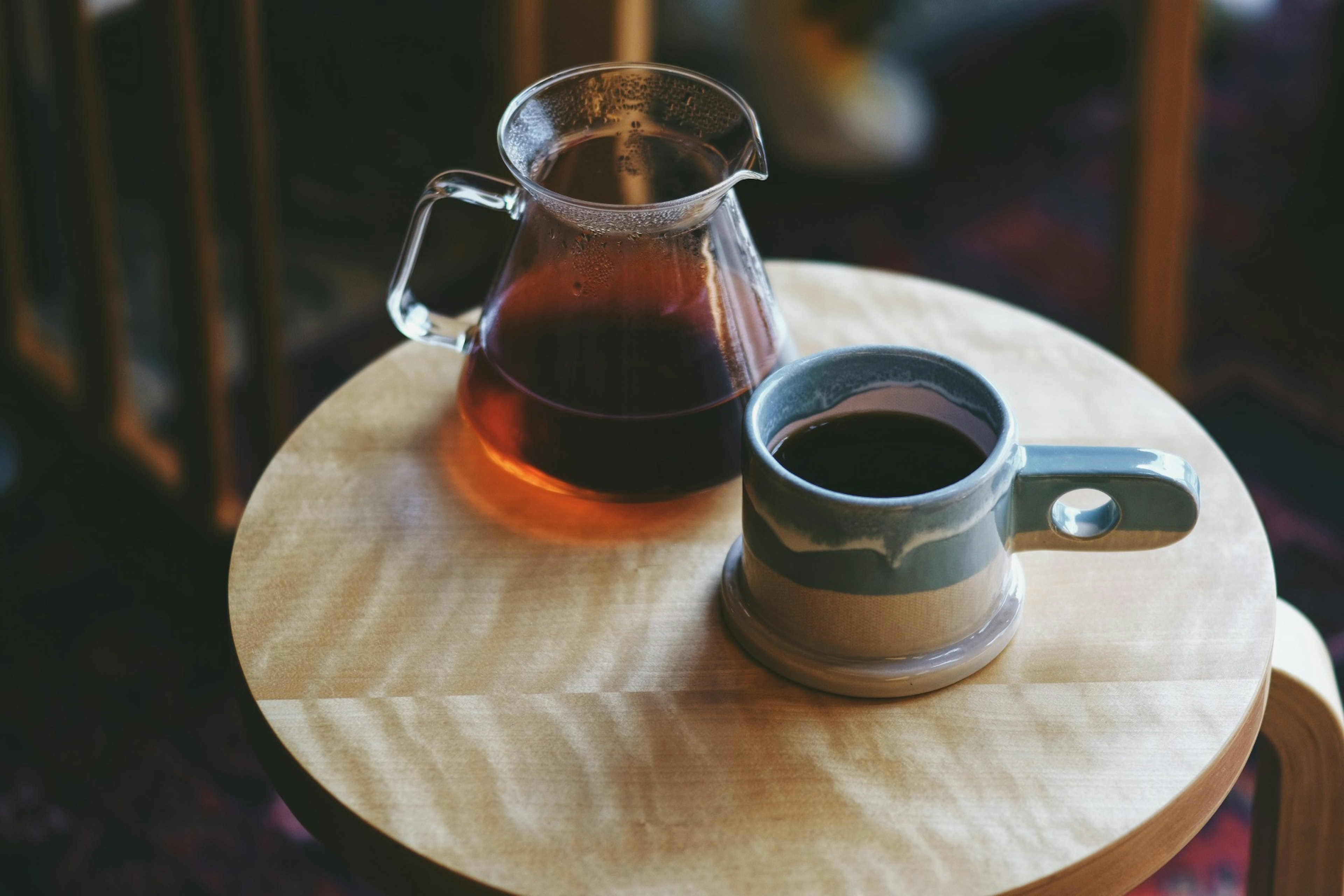 Cangkir dan teko kopi di atas meja kayu