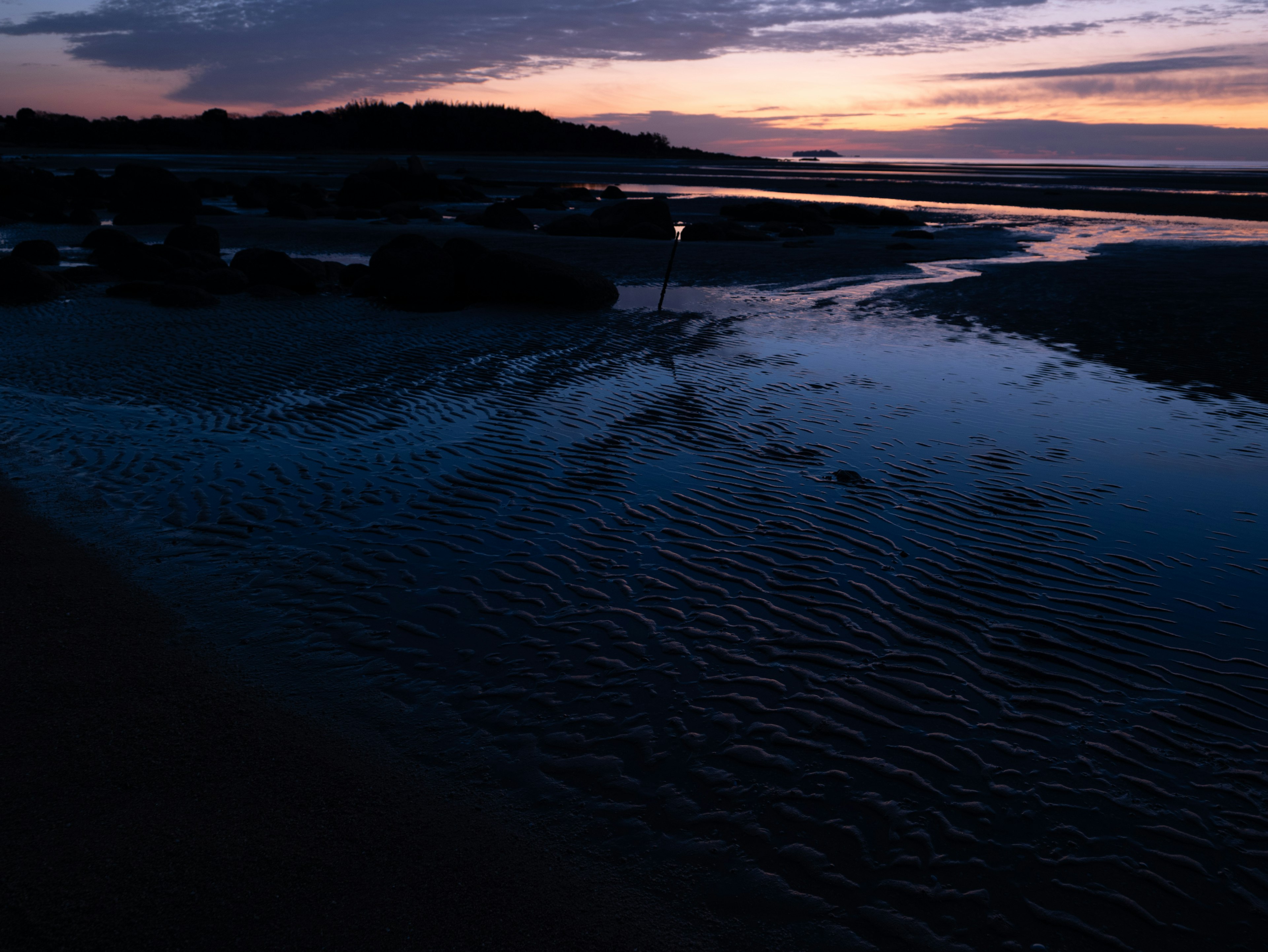 夕焼けに照らされた静かな河口の風景水面に映る色合い