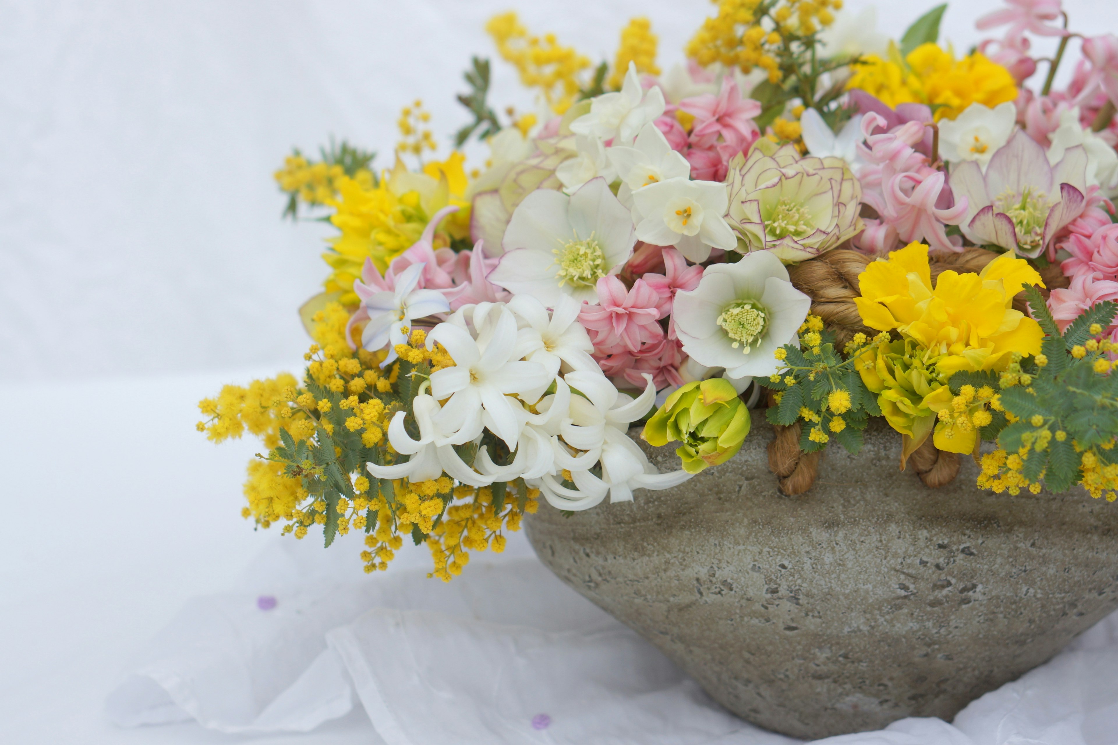 色とりどりの花が盛り込まれた美しい花束 段ボールのような器にアレンジされている