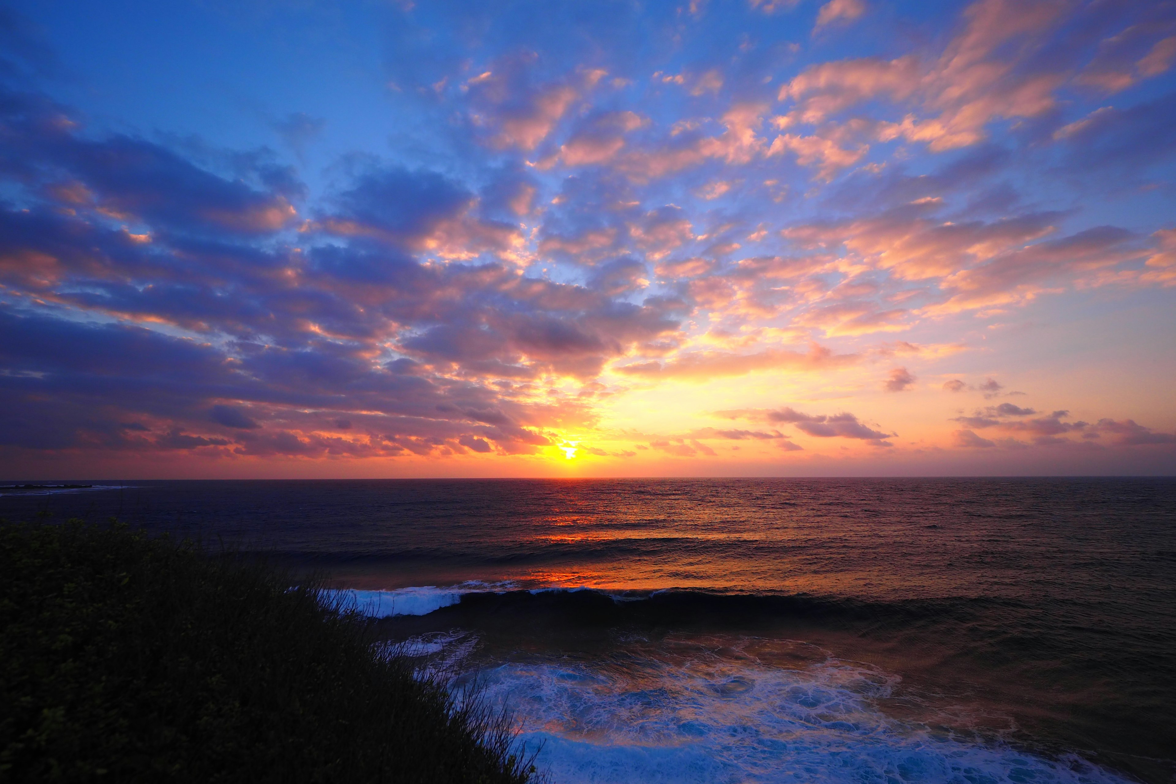 Hermoso paisaje con una puesta de sol sobre el océano y nubes coloridas