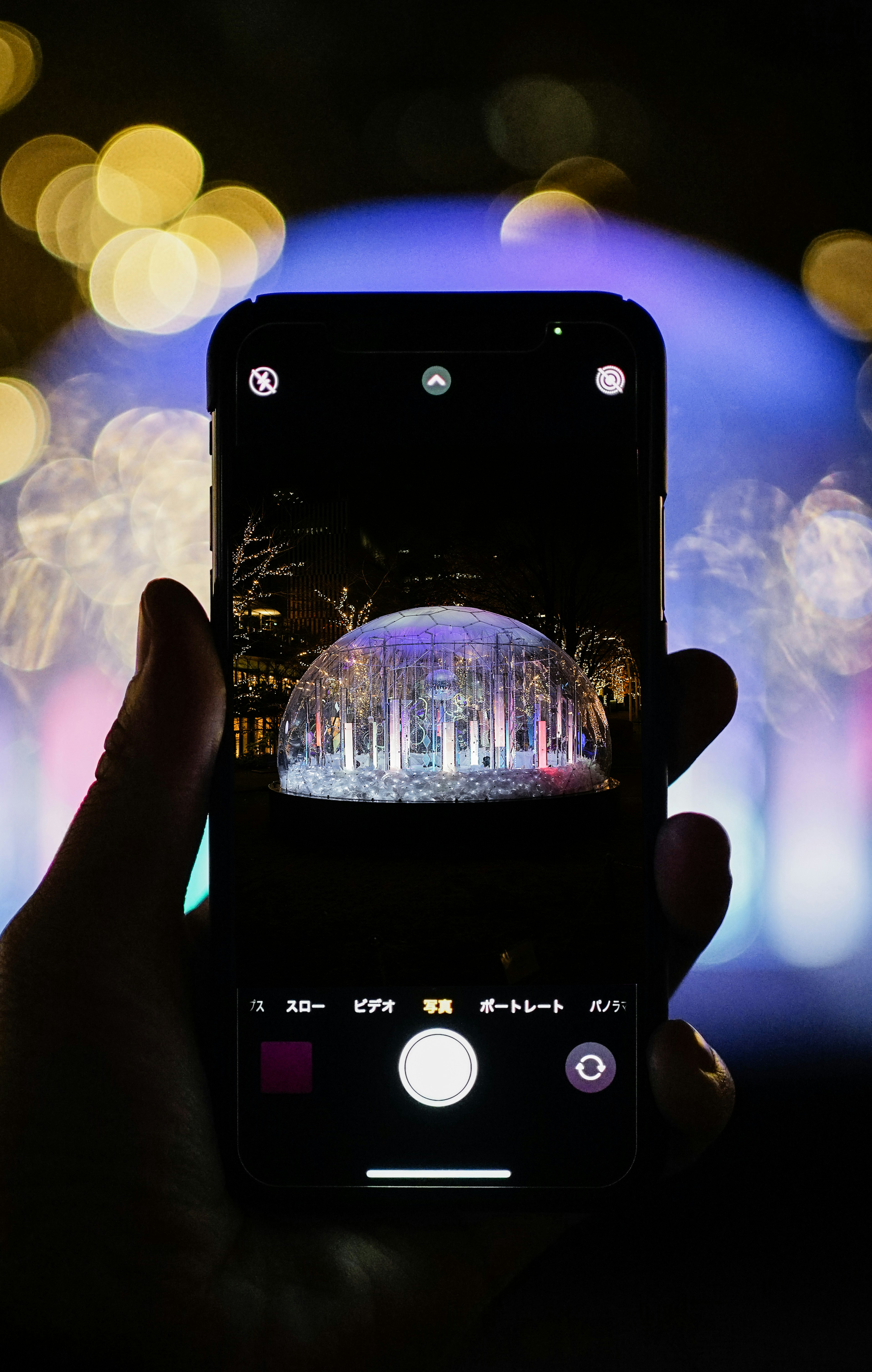 A hand holding a smartphone capturing a beautiful light display