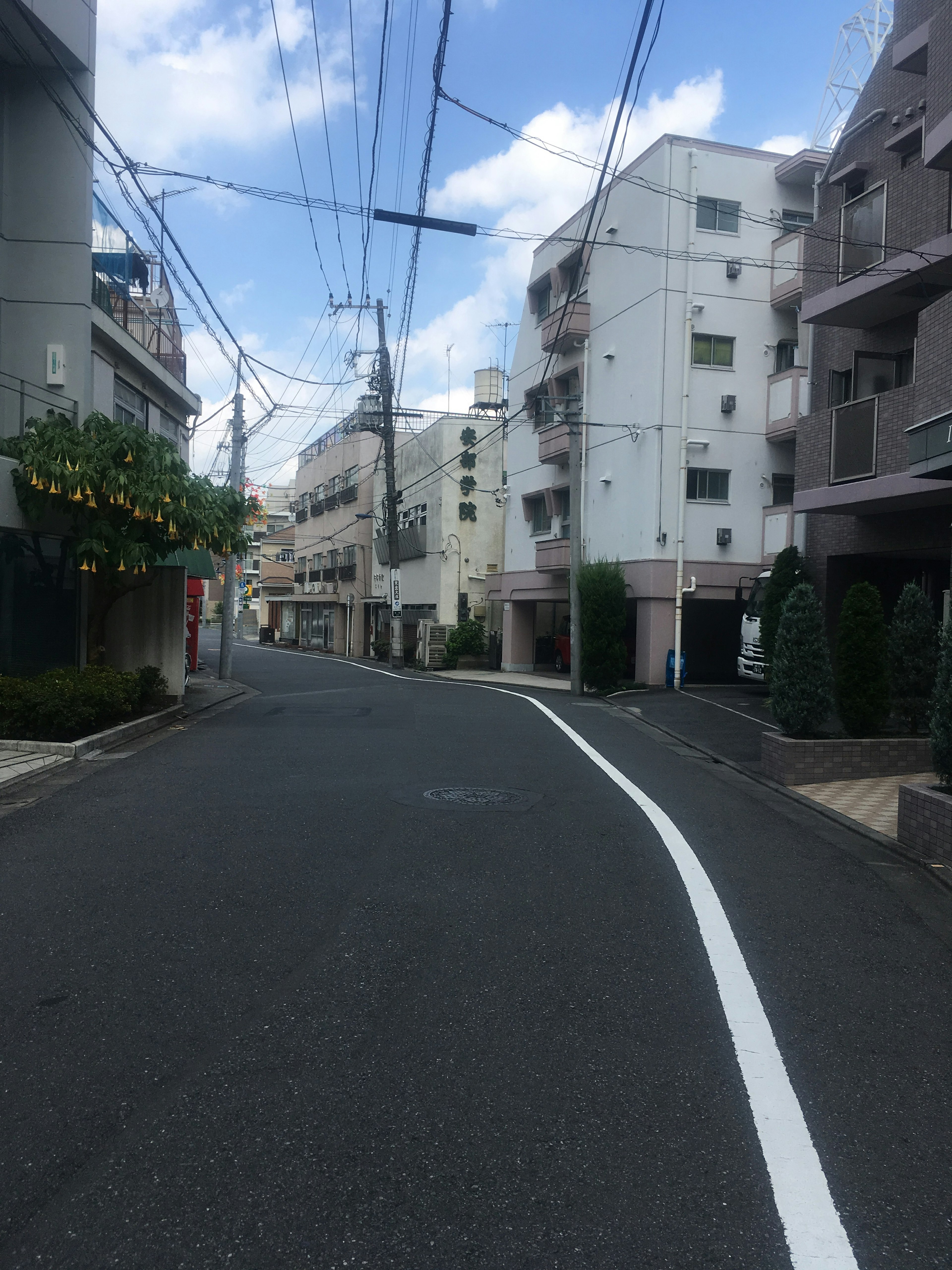 静かな街並みの風景で、青空と白い雲が見える