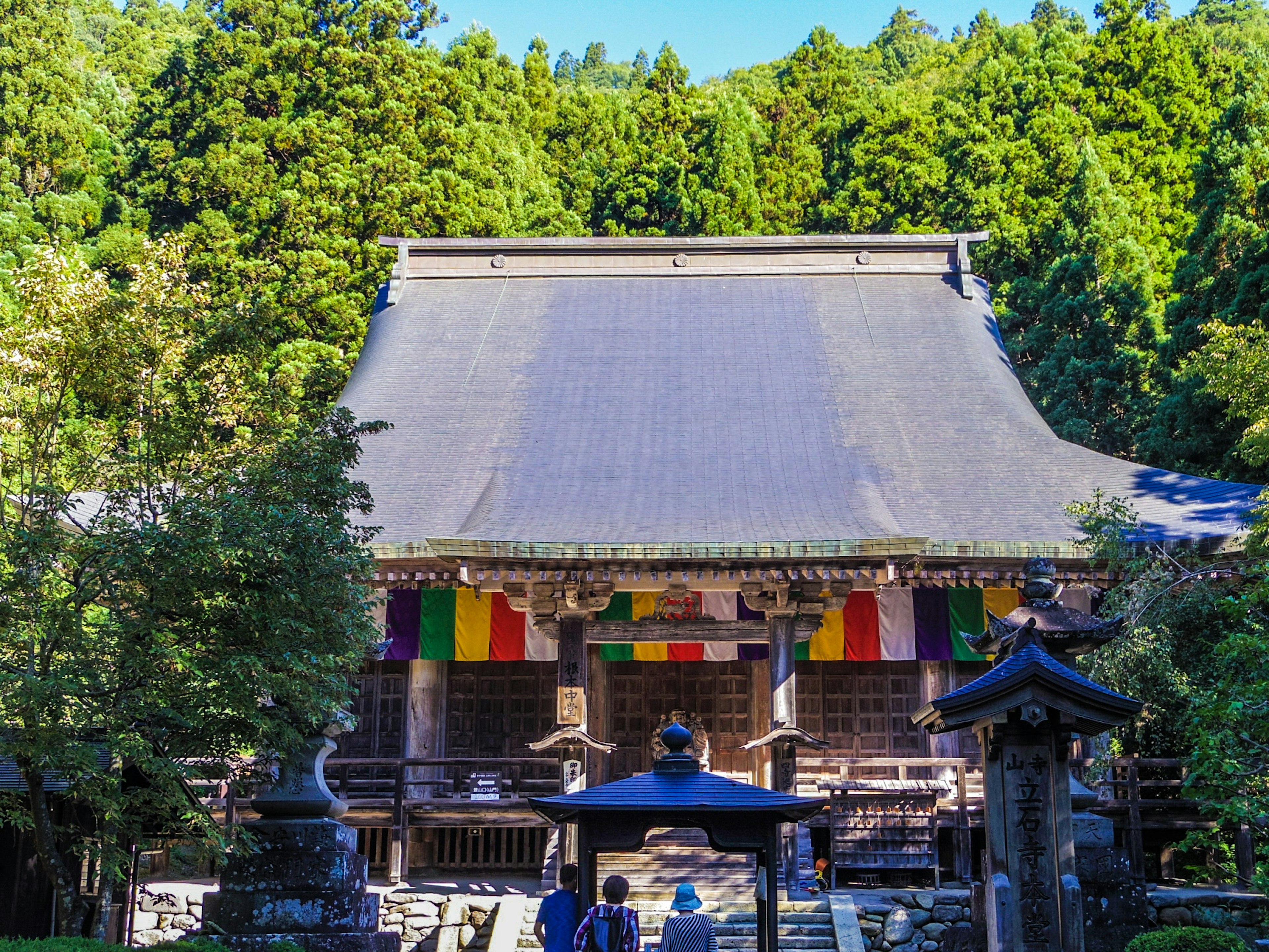 Äußere eines traditionellen japanischen Tempels, umgeben von üppigem Grün