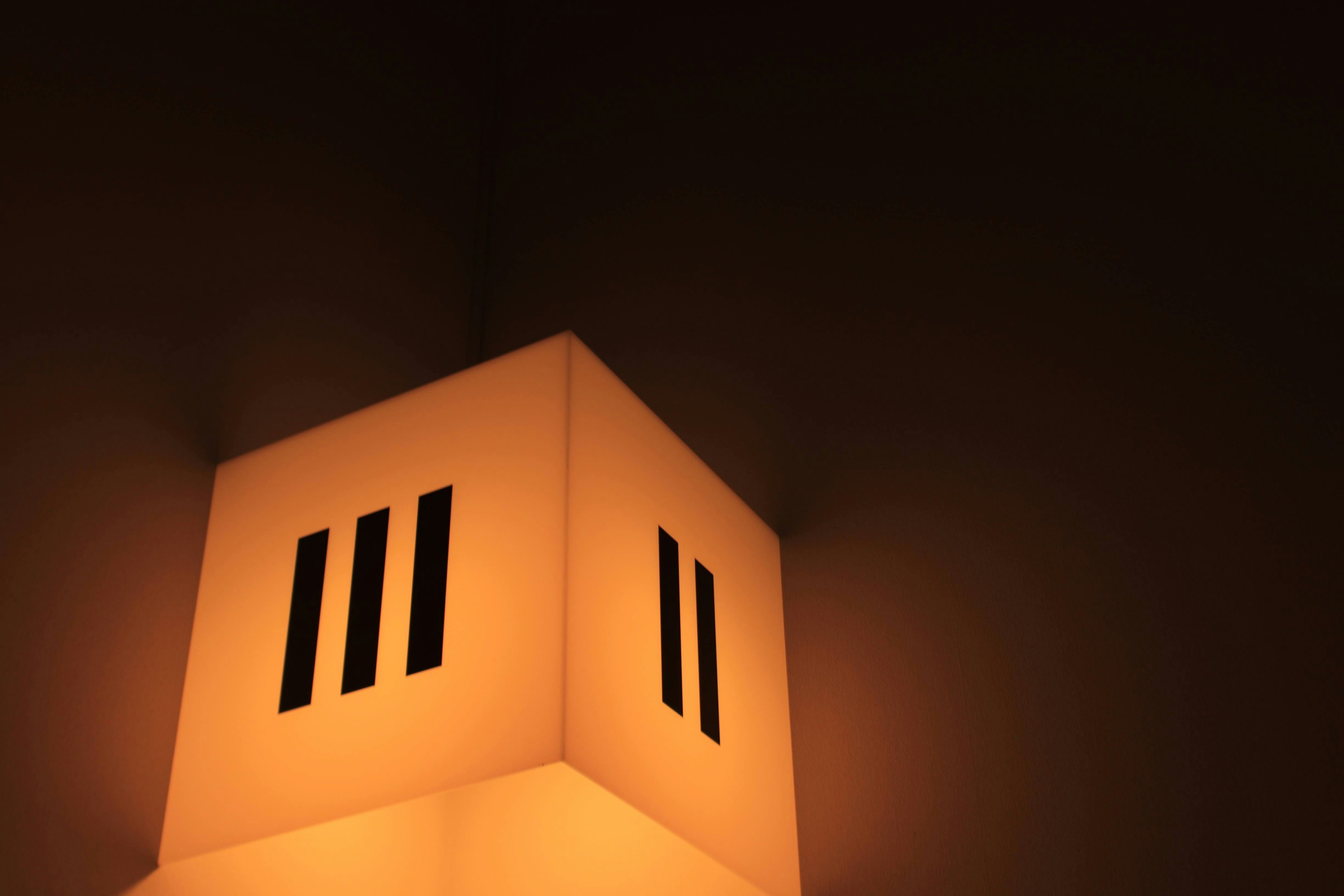 Une lampe émettant une lumière orange chaude placée dans le coin d'un mur