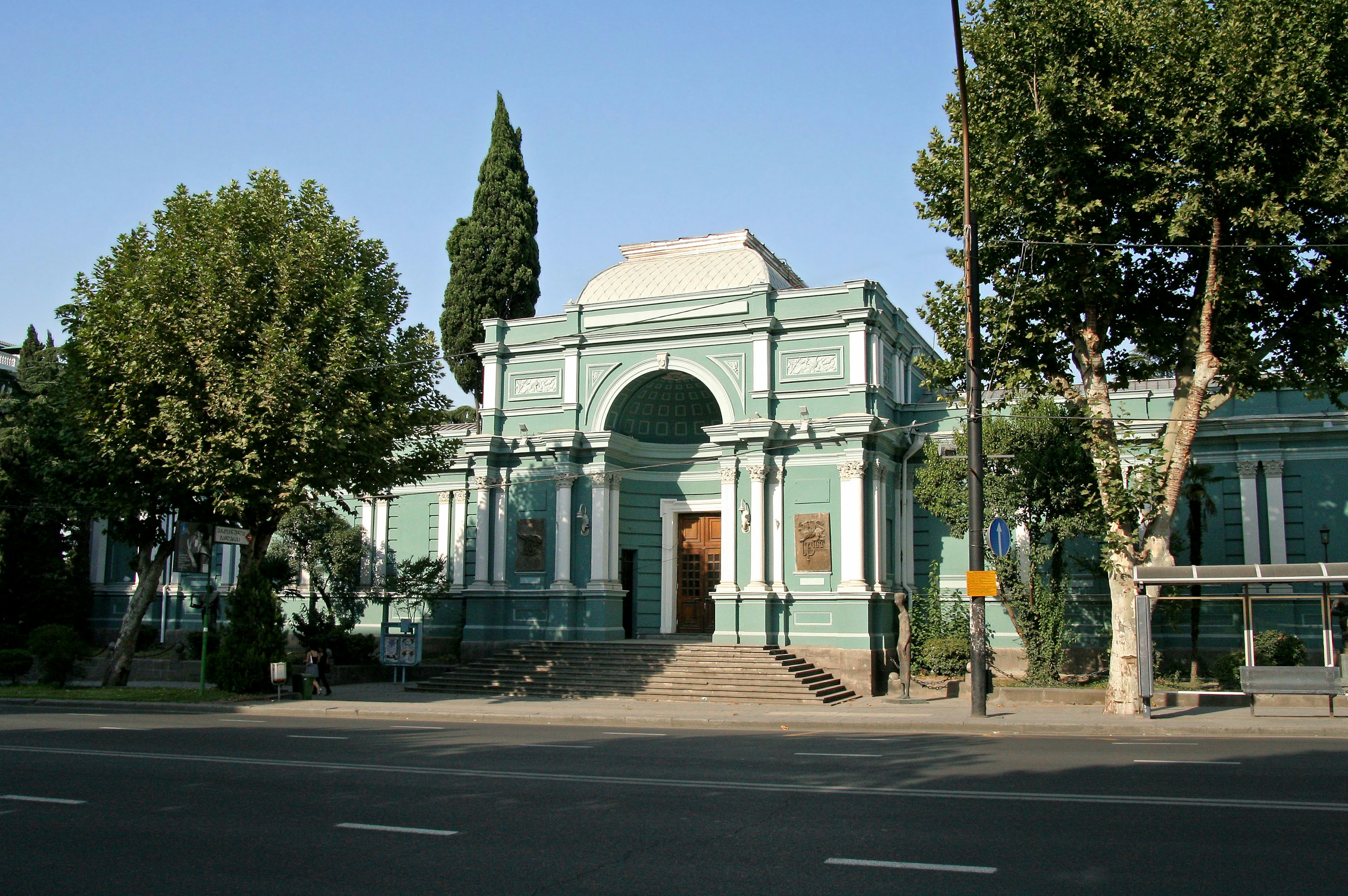 Historic building with green exterior and large archway entrance