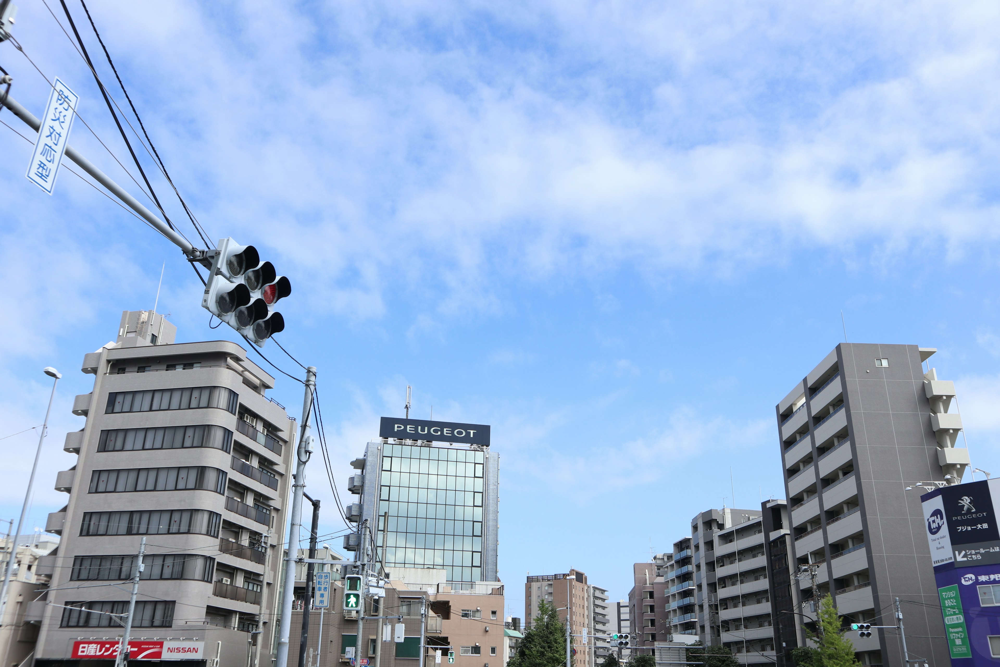 Urban landscape featuring modern buildings and traffic lights under a blue sky