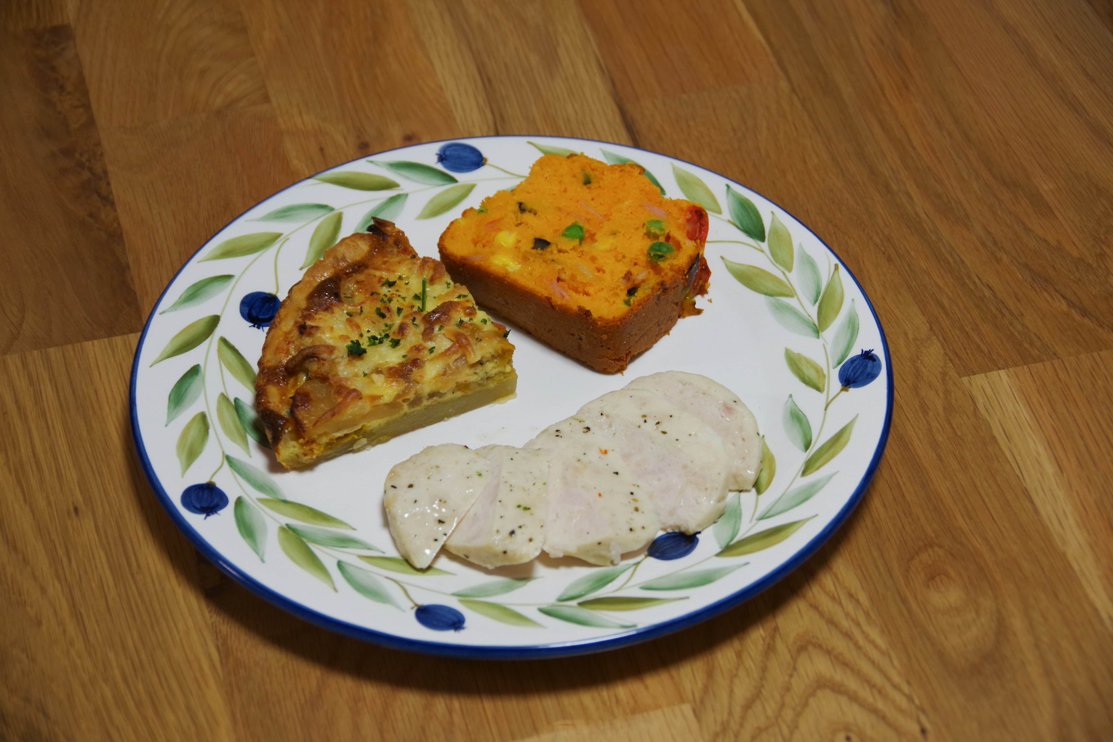 Un plato con una variedad de platos que incluye un plato de huevo un plato de verduras coloridas y rodajas de pollo