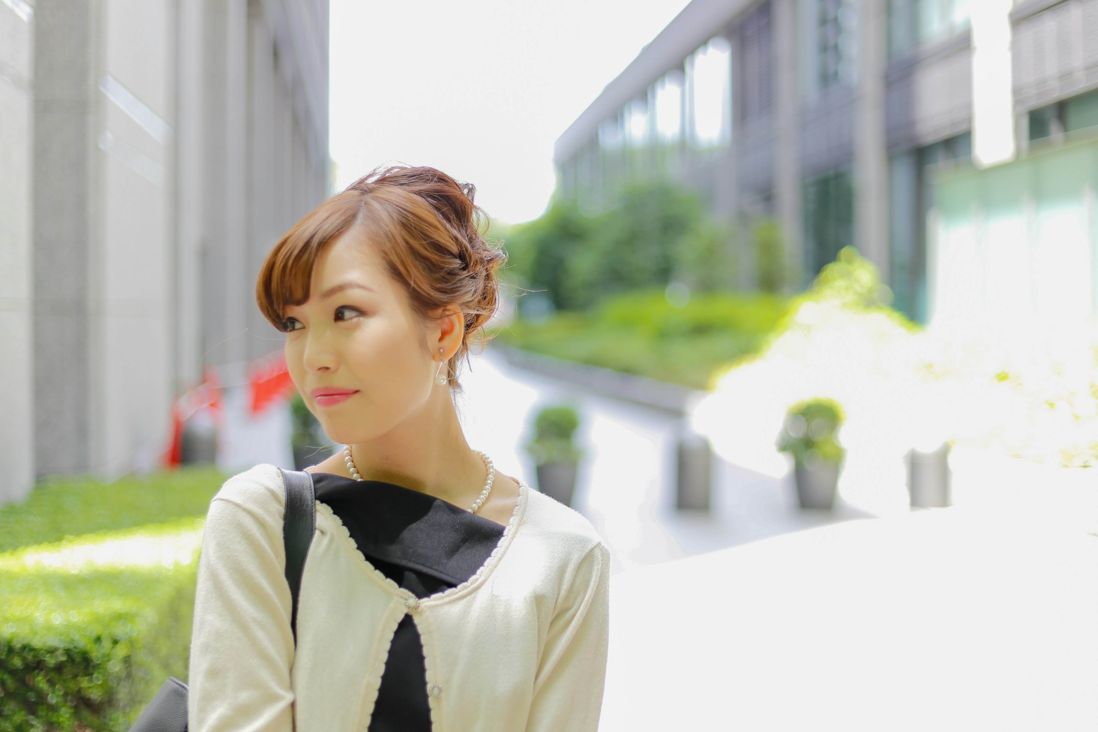 Young woman relaxing in a park with modern buildings and greenery in the background