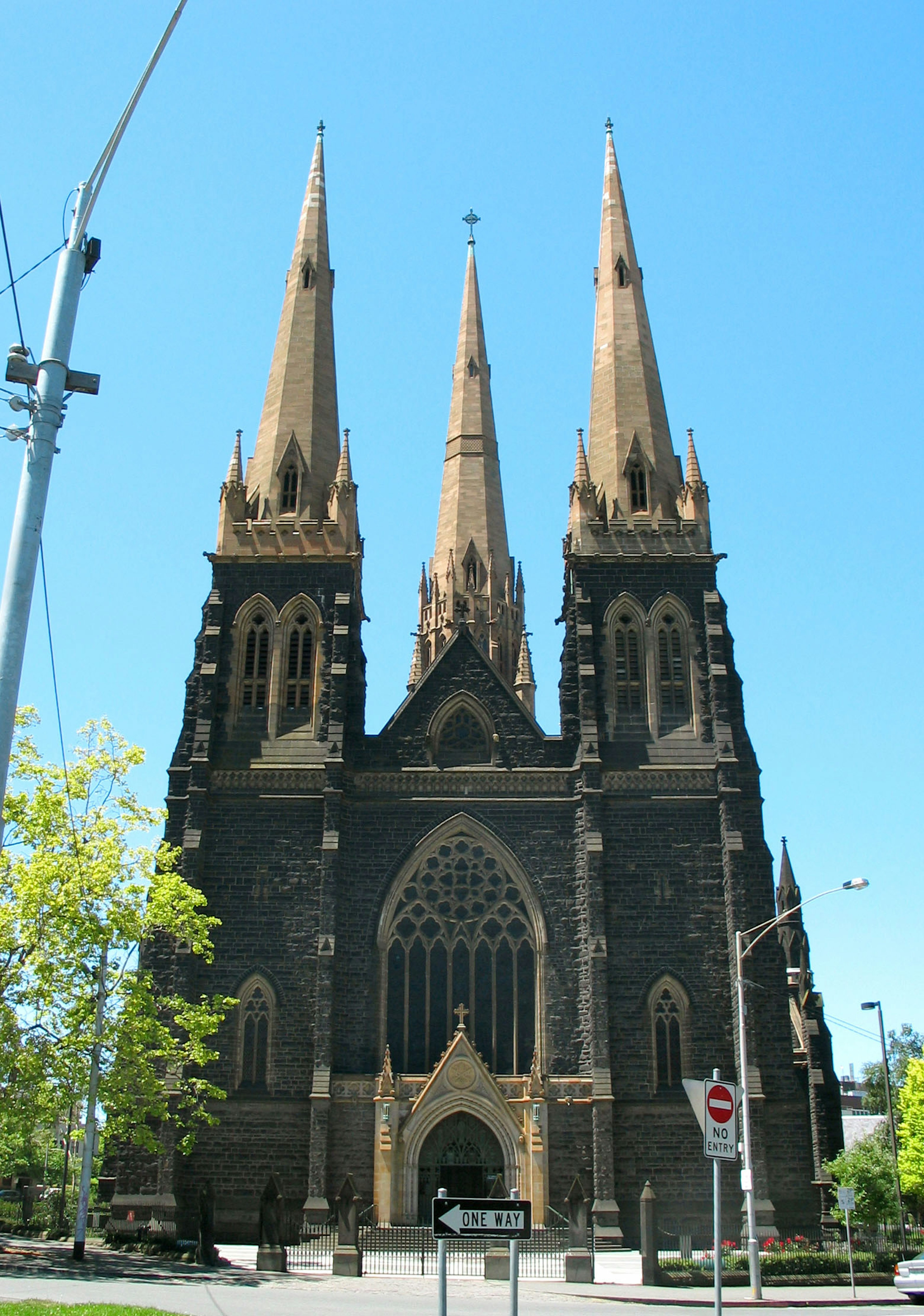 Exterior view of a Gothic-style church with three spires