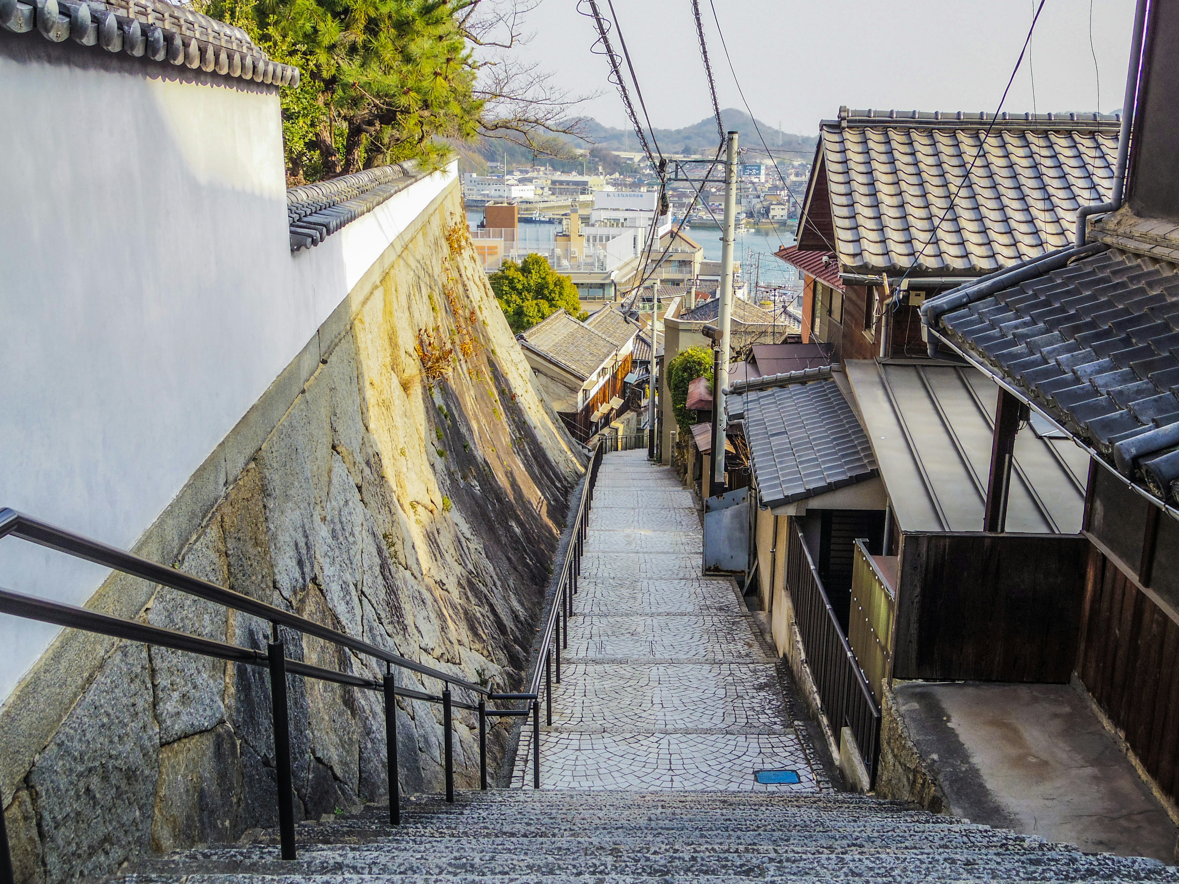 Escaleras de piedra que descienden entre casas japonesas tradicionales