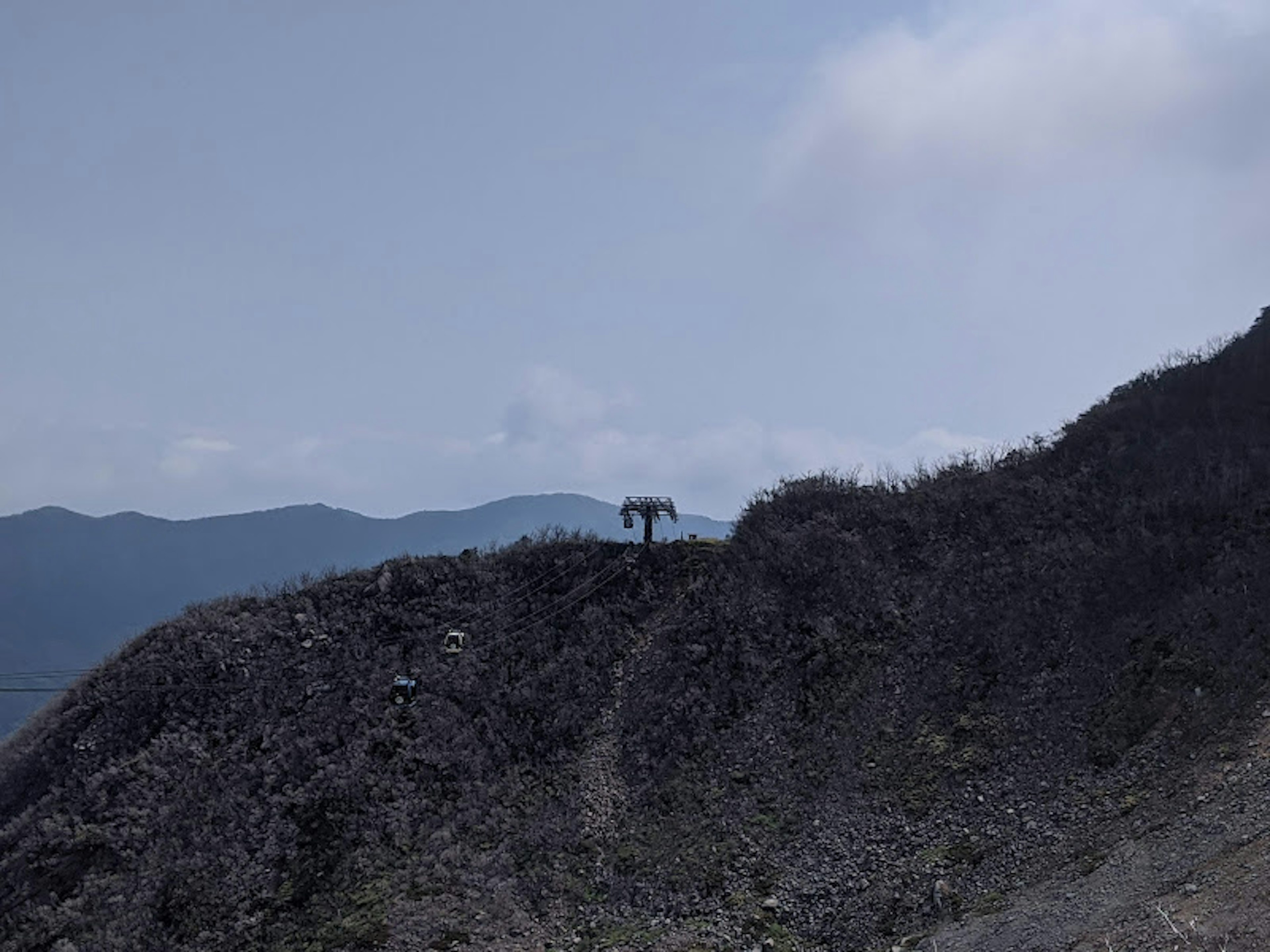 山の頂上に立つ登山者のシルエットと青空