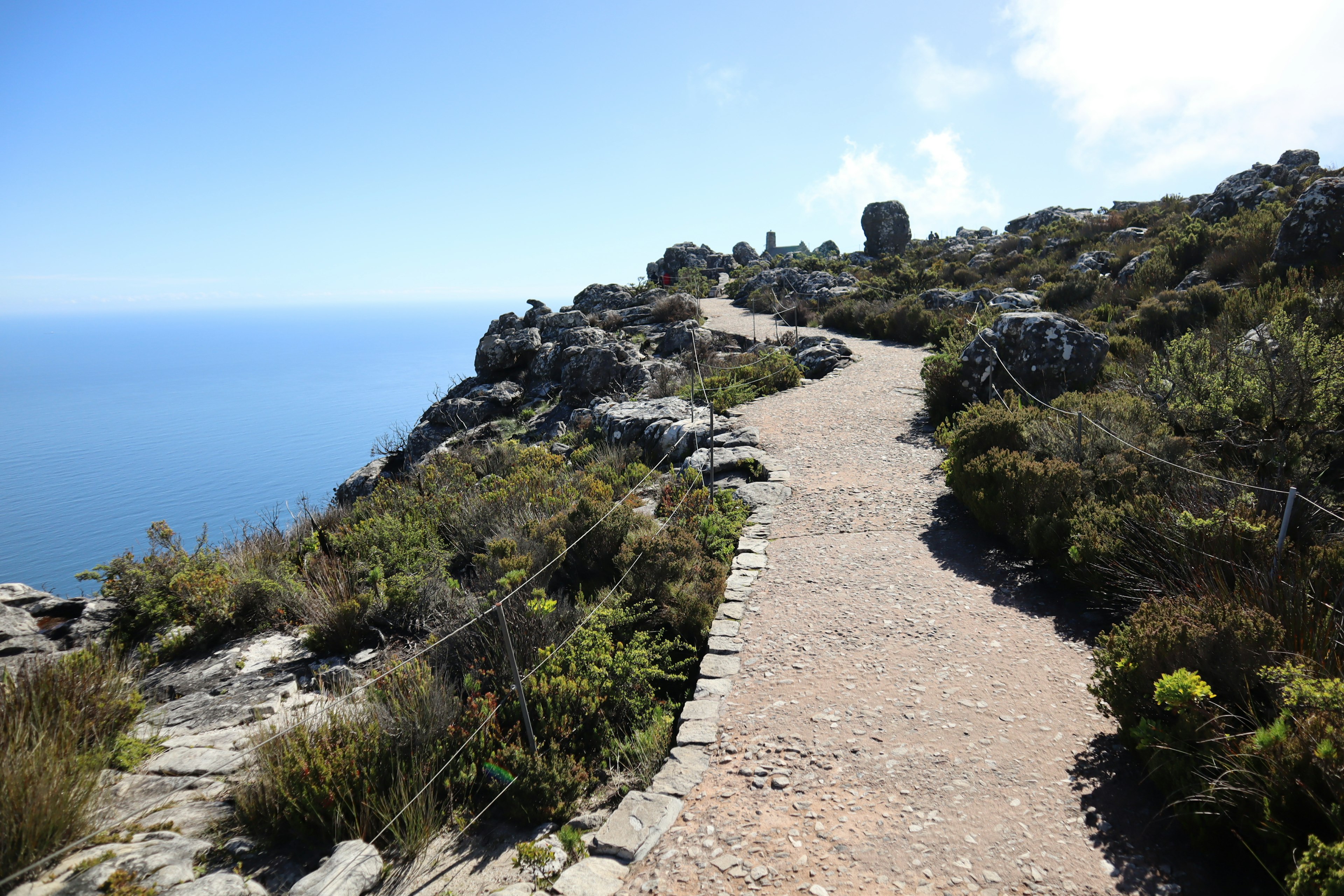 Chemin panoramique le long d'un terrain rocheux avec vue sur la mer