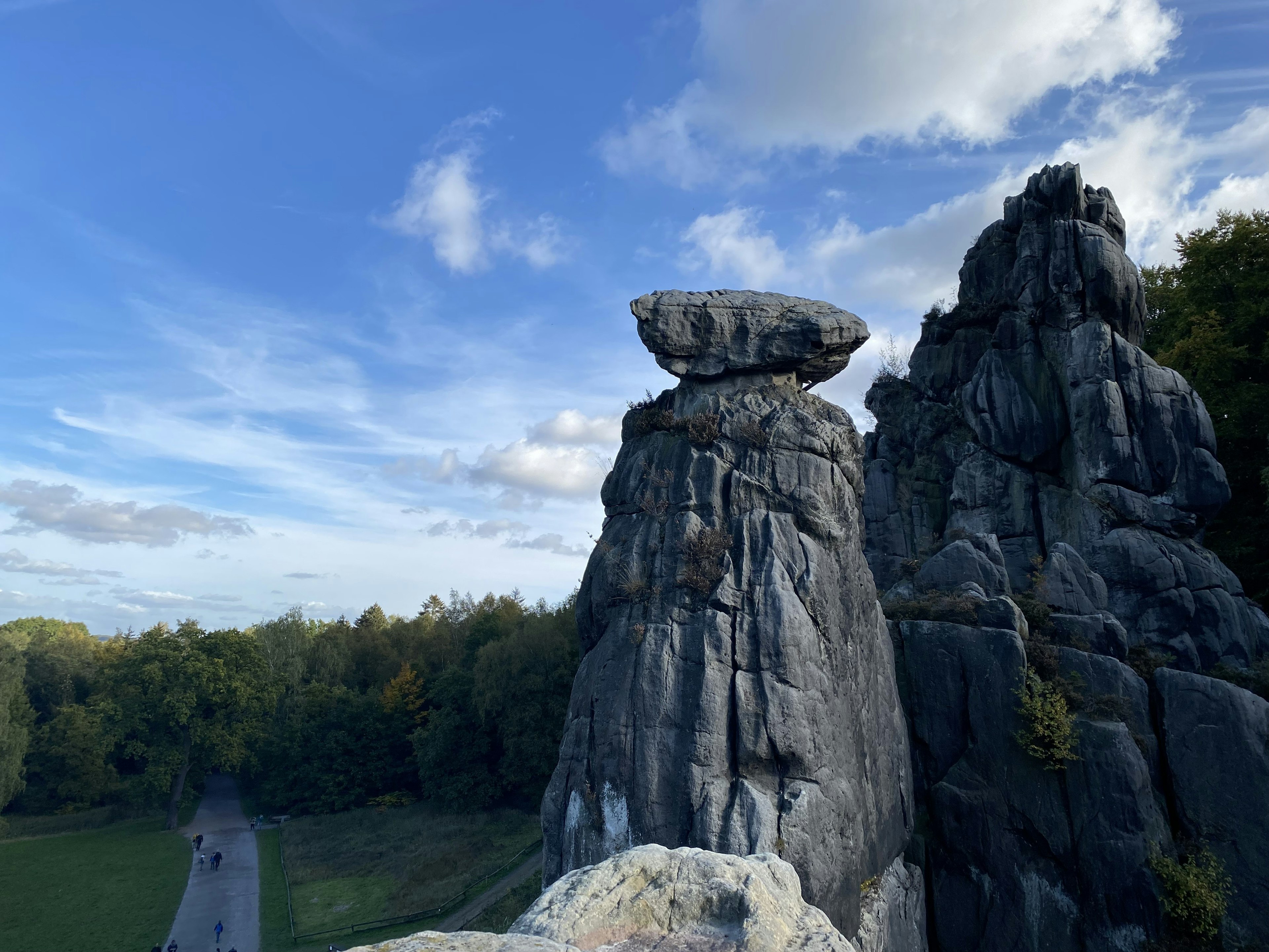 青空の下にそびえる奇岩と森林の風景